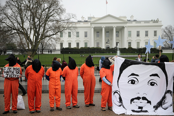 Demonstrators with the group Witness Against Torture dress in orange jumpsuits, wear black hoods and hold a banner with the image of Mohammed al Hamiri while demanding that U.S. President Barack Obama close the military prison in Guantanamo, Cuba, outside the White House  January 8, 2016 in Washington, DC. AChip Somodevilla&mdash;Getty Images (Chip Somodevilla&mdash;Getty Images)