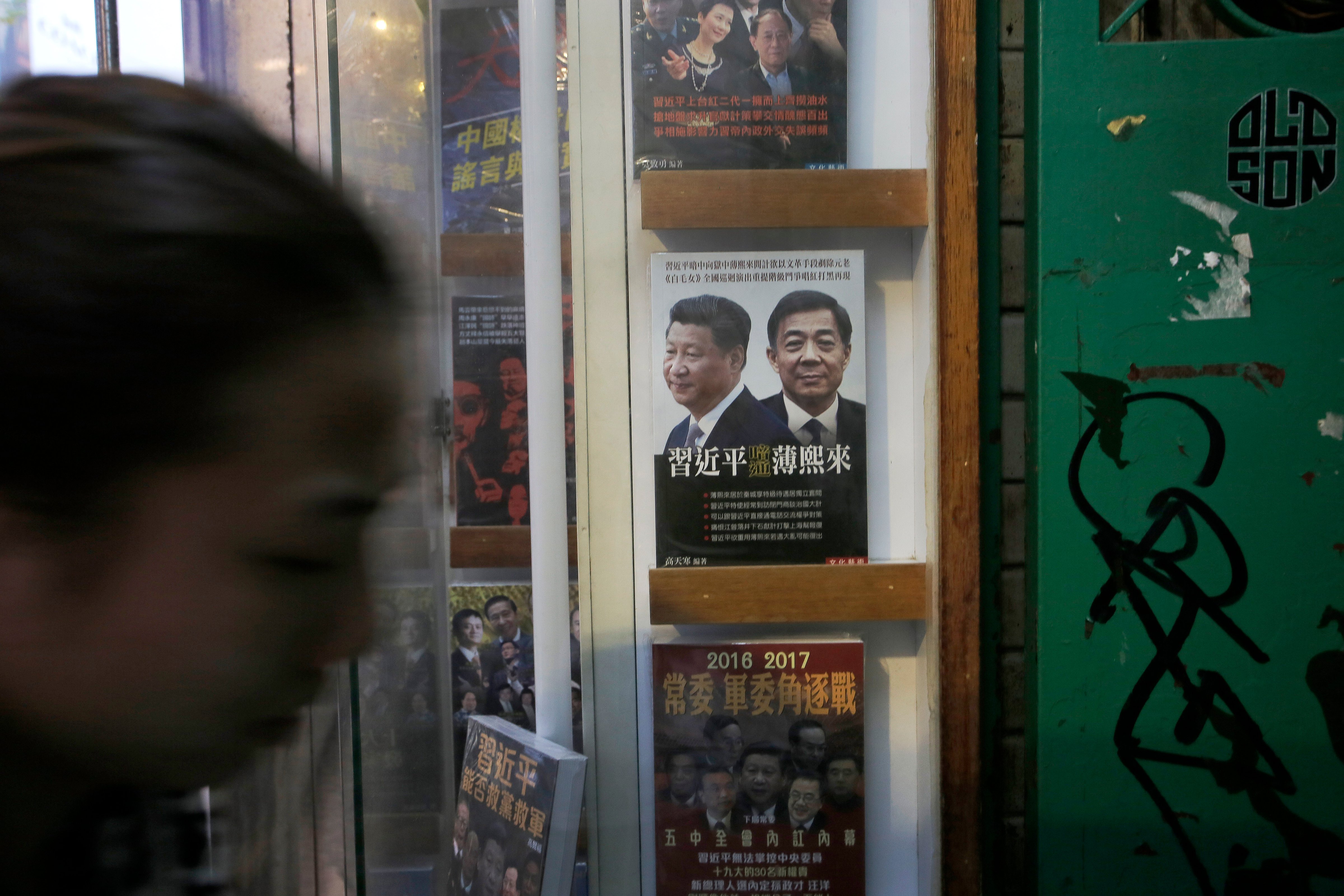 A woman walks past a book featuring a photo of Chinese President Xi Jinping, left, and former Chongqing city party leader Bo Xilai on the cover, at the entrance of the closed Causeway Bay Books shop (Vincent Yu—AP)