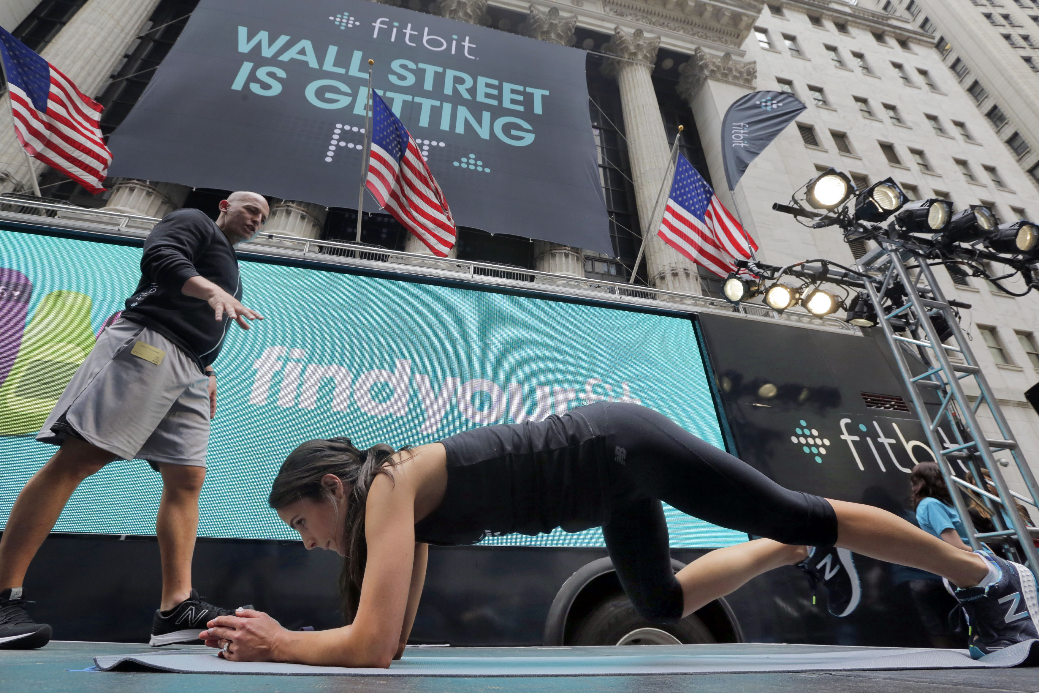 From left: Fitness expert Harley Pasternak and actress Jordana Brewster lead a work out on behalf of Fitbit, in front of the New York Stock Exchange, June 18, 2015. (Richard Drew—AP)