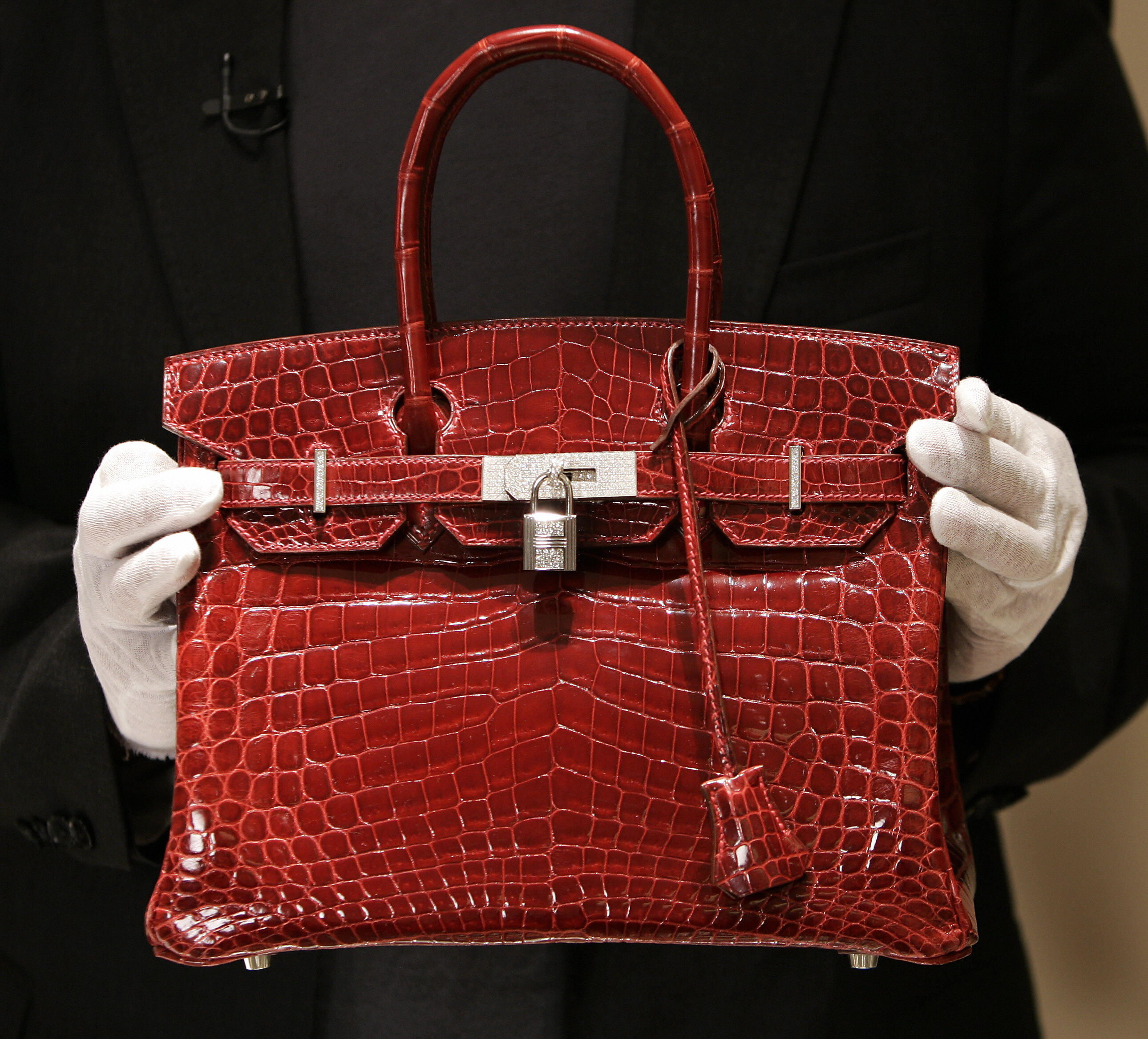 A employee holds a $129,000 crocodile Hermes Birkin Bag during a private opening for the new Hermes store on Wall Street in New York 21 June 2007.