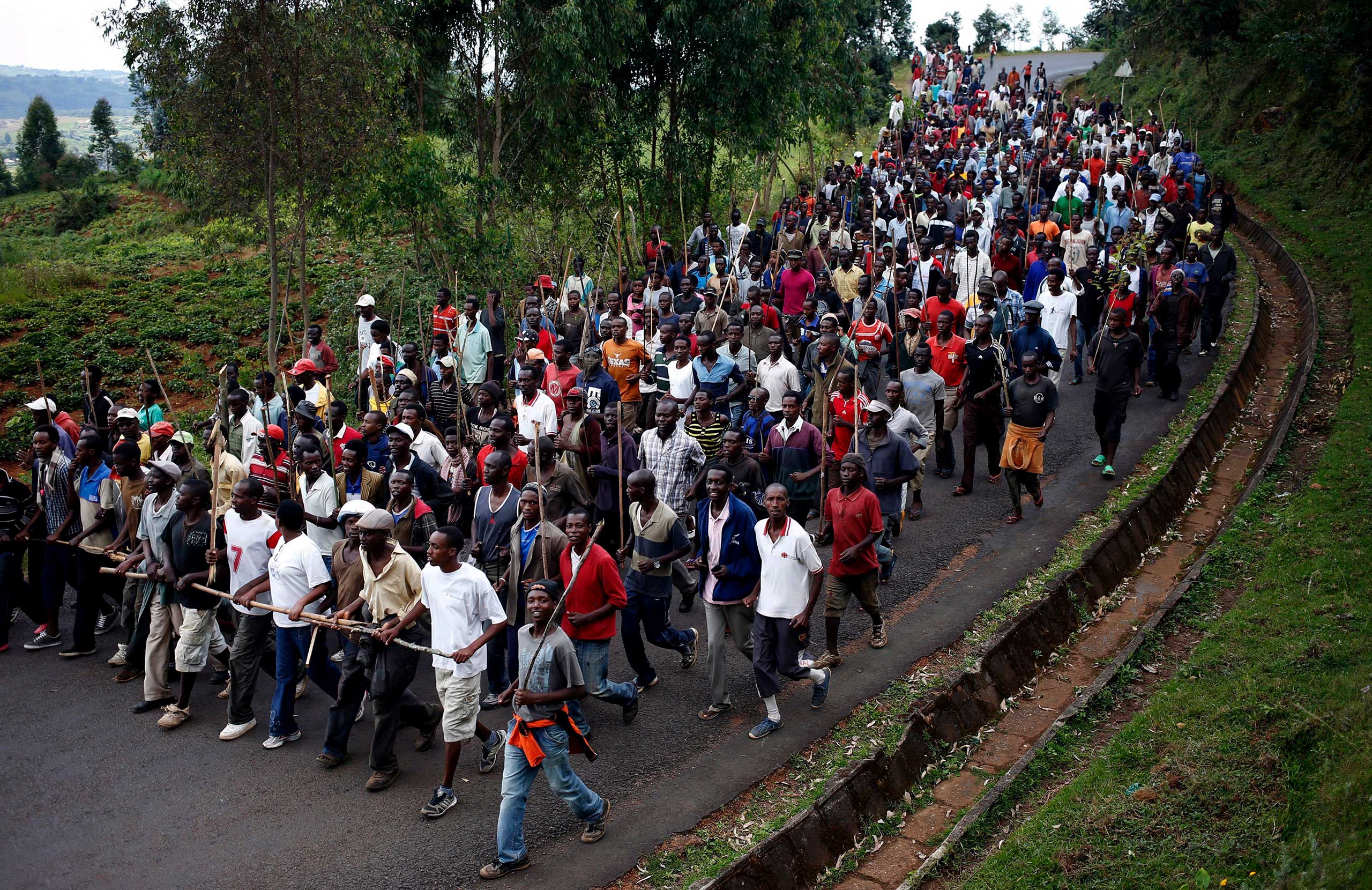 Protesters who are against Burundi President Pierre Nkurunziza and his bid for a third term march towards the town of Ijenda, Burundi
