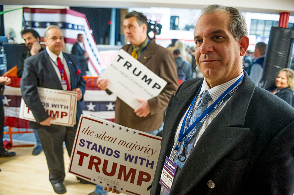 Campaign volunteer George Vazquez, hands out signs to supporters before a Donald Trump campaign rally at Stevens High School on January 5, 2016, in Claremont, New Hampshire.