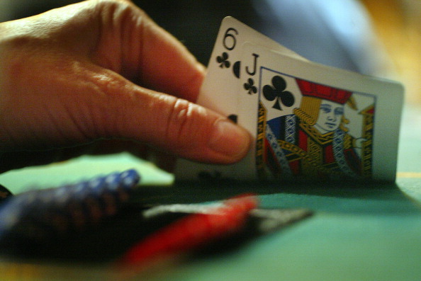 A player peeks at their hand, the popularity of Texas Hold 'Em Poker is increasing, both online and in person. Philthy McNasty's, on Eglinton Avenue East has tournaments every Monday in Toronto, March 7, 2005. (Steve Russell—Toronto Star via Getty Images)