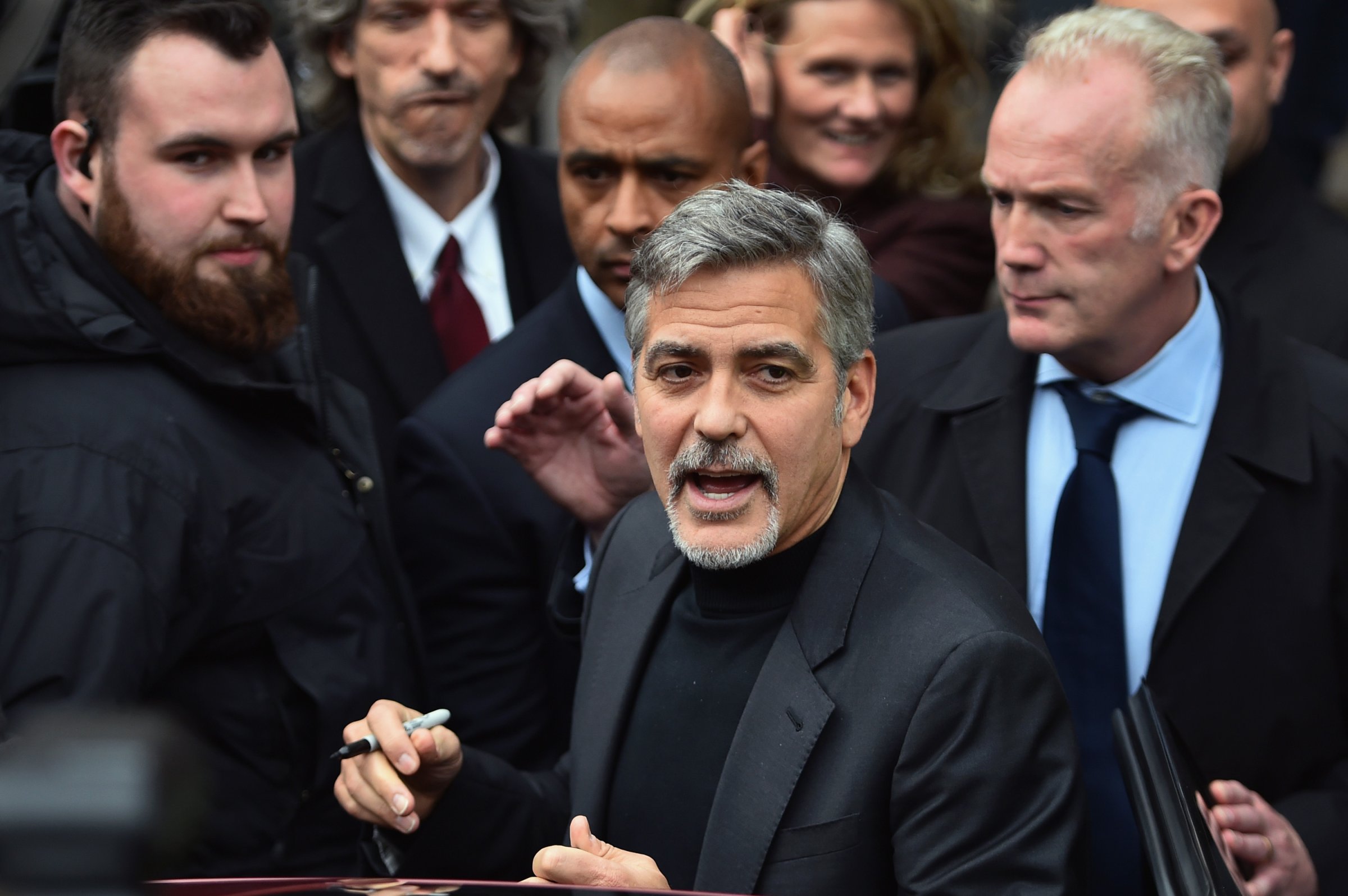 Hollywood actor George Clooney reacts with members of the public as he leaves Tiger Lily restaurant on Nov. 12, 2015 in Edinburgh, Scotland.
