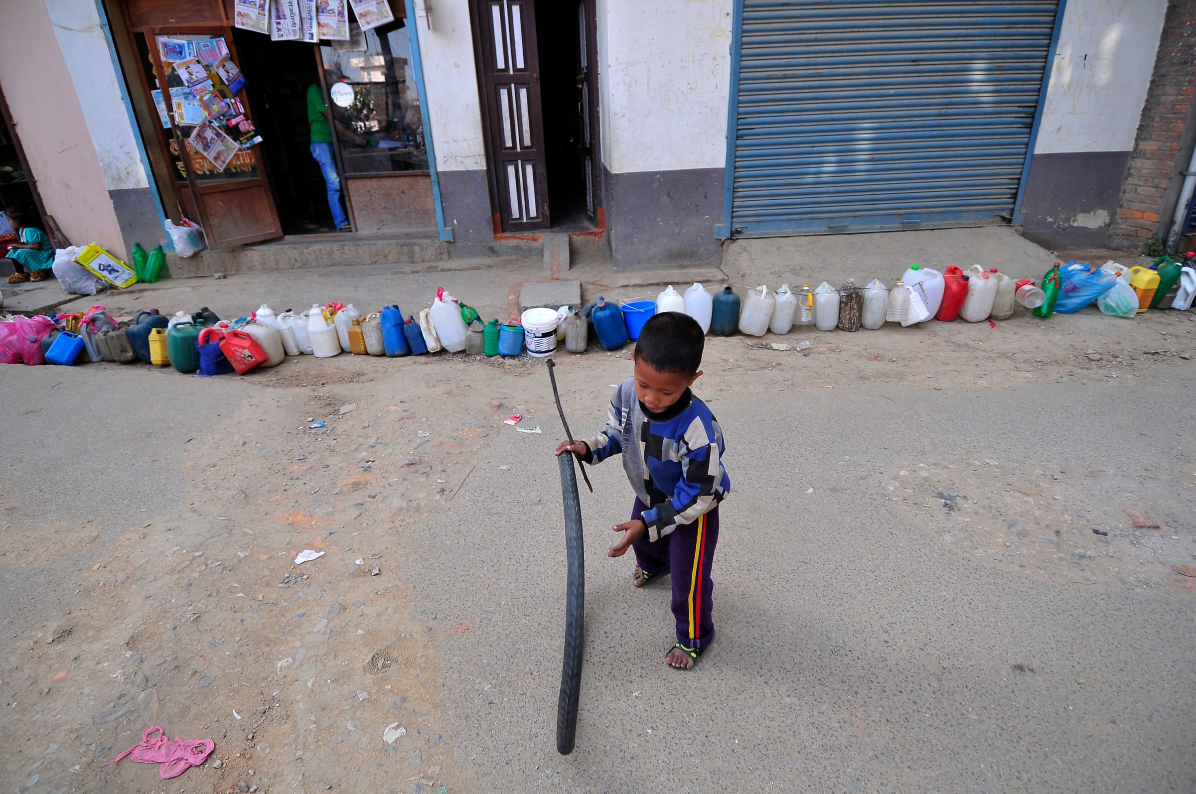 A Nepalese kid plays while waiting for his parents' time to