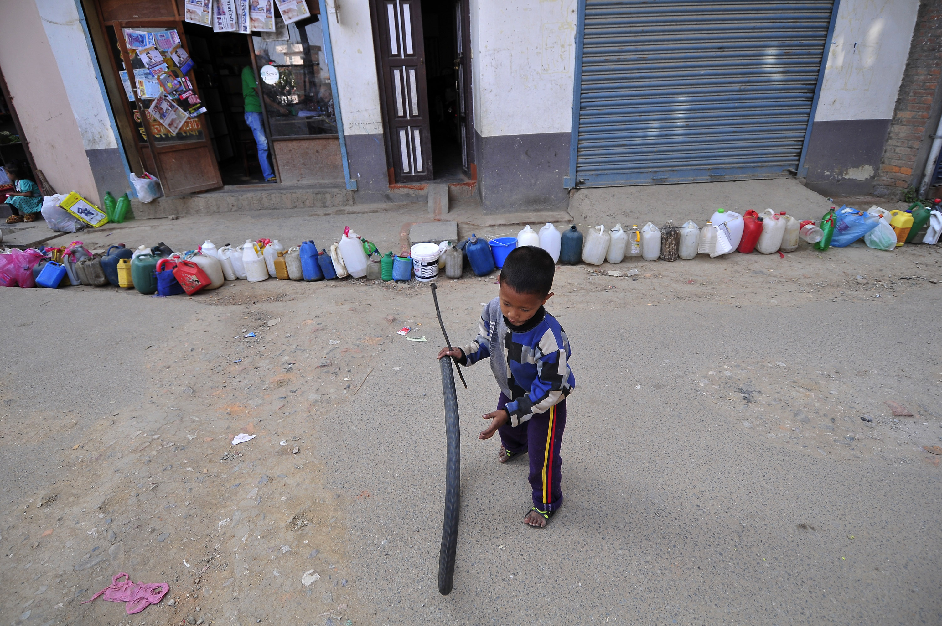 A Nepalese child plays while waiting for his parents' time to buy kerosene. Protests at the border with India have blocked the transportation of fuel and daily commodities to Nepal. (Narayan Maharjan—Pacific Press/LightRocket/Getty Images)