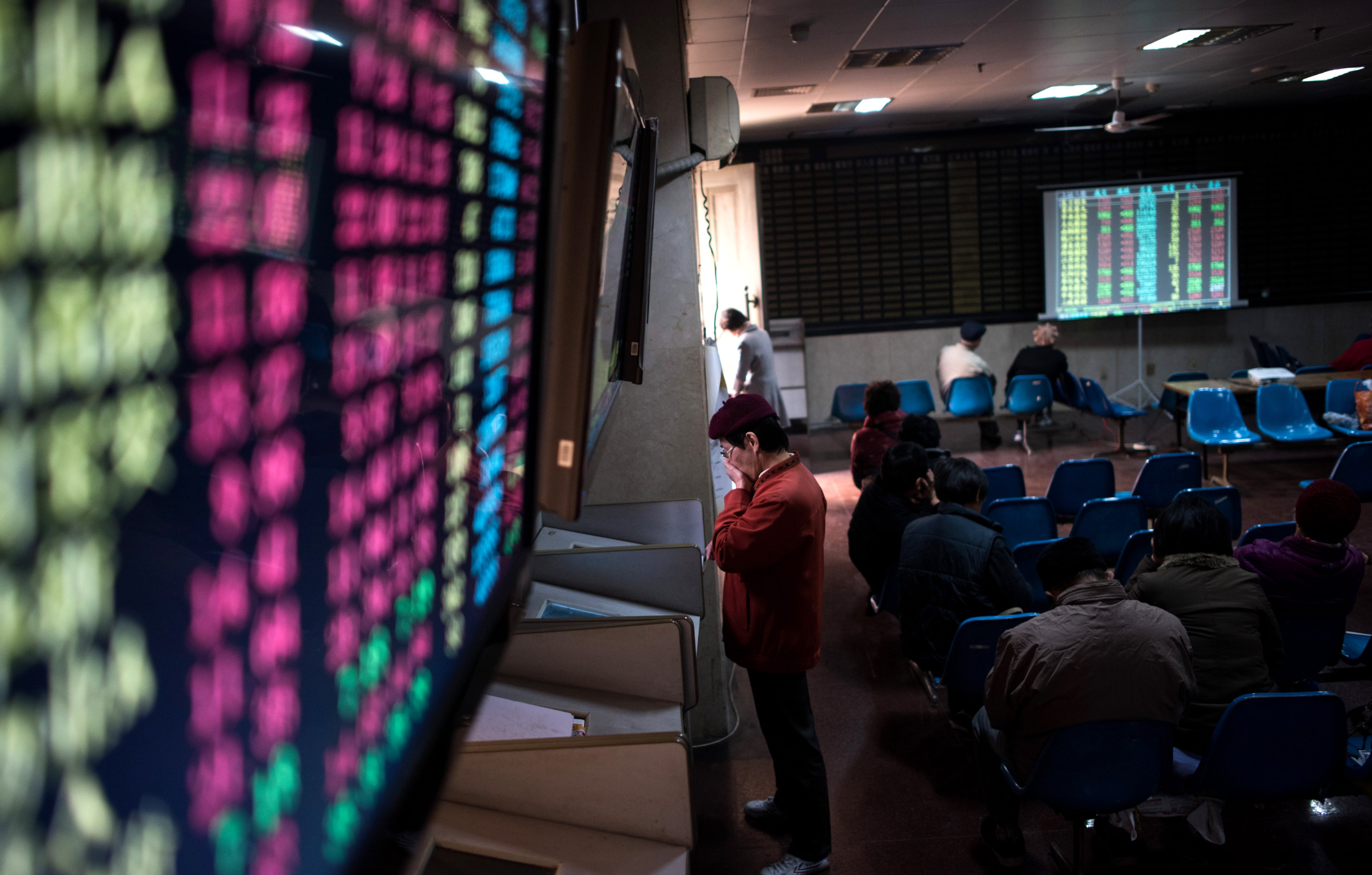 In this photo taken on December 15, 2015, an investor monitors screens showing stock market movements at a brokerage house in Shanghai. (AFP/Getty Images)