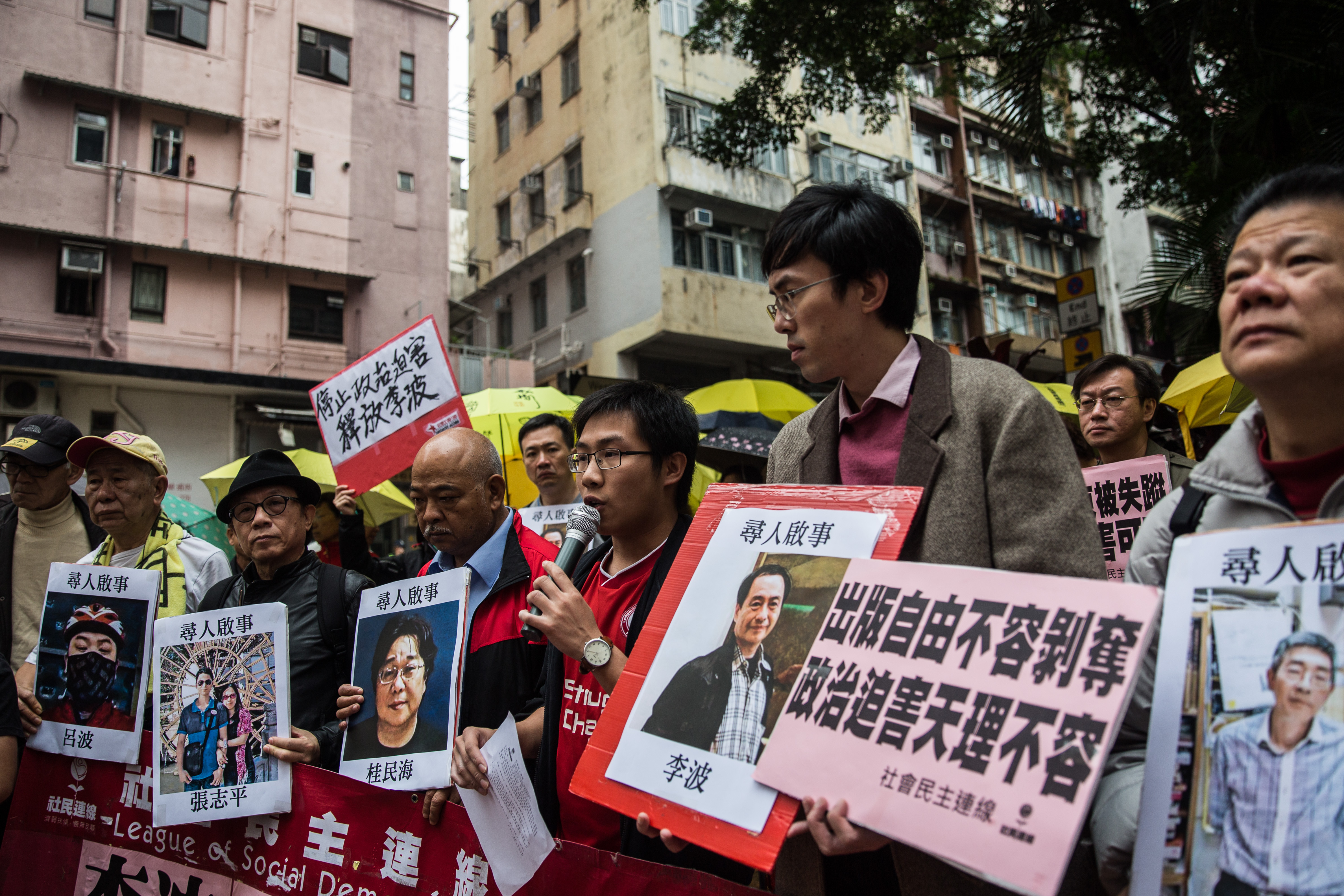 Protesters hold up images of missing publishers of books critical of China, including the latest to vanish, Lee Bo, as they walk toward China's Liaison Office in Hong Kong on Jan, 3, 2016 (Anthony Wallace—AFP/Getty Images)