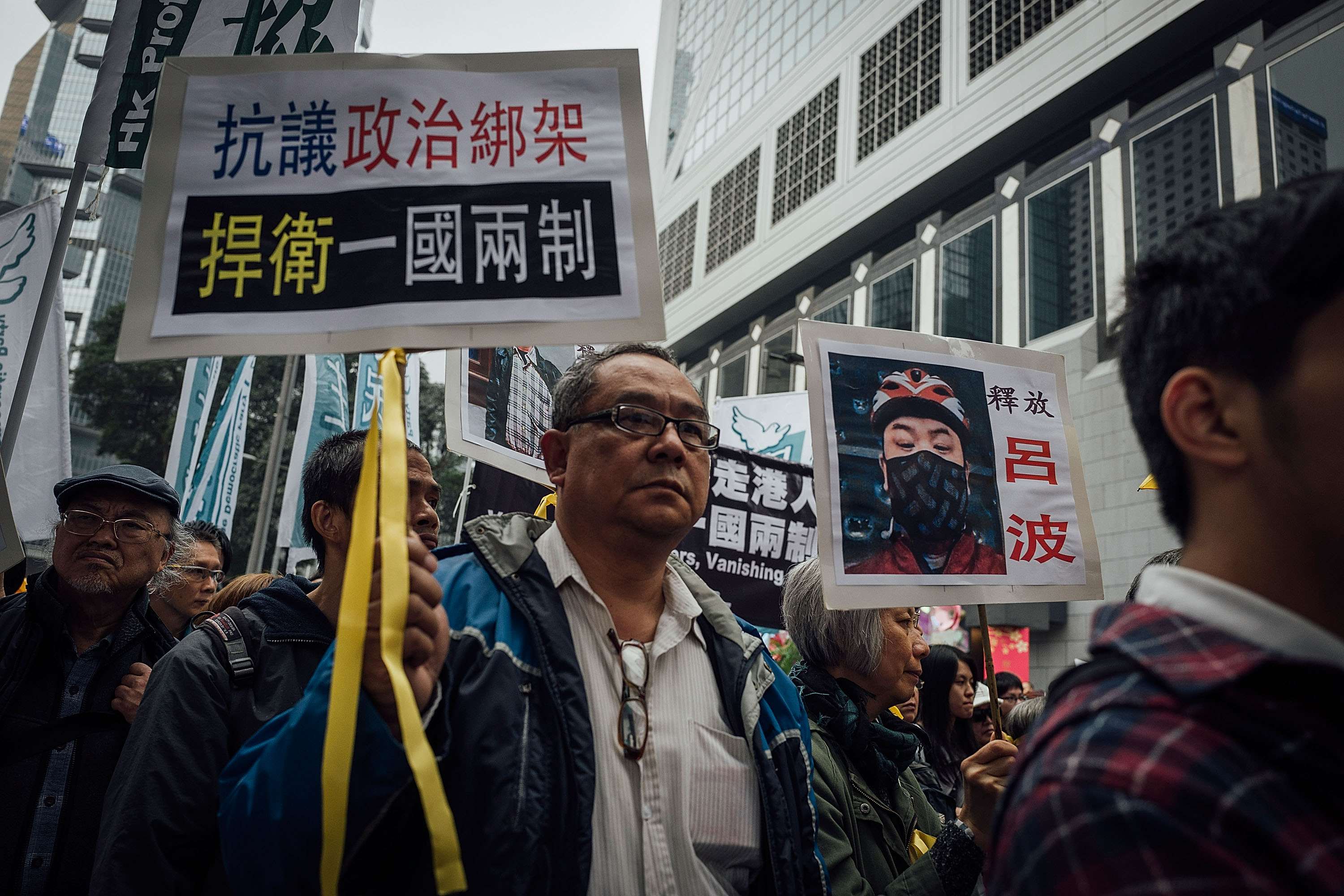 People hold placards and shout slogans as they take part in a rally on a street on Jan. 10, 2016, in Hong Kong. The disappearance of five Hong Kong booksellers, including U.K. passport holder Lee Bo, has sent shivers through Hong Kong as anxiety grows that Chinese control over the city is tightening (Anthony Kwan—Getty Images)