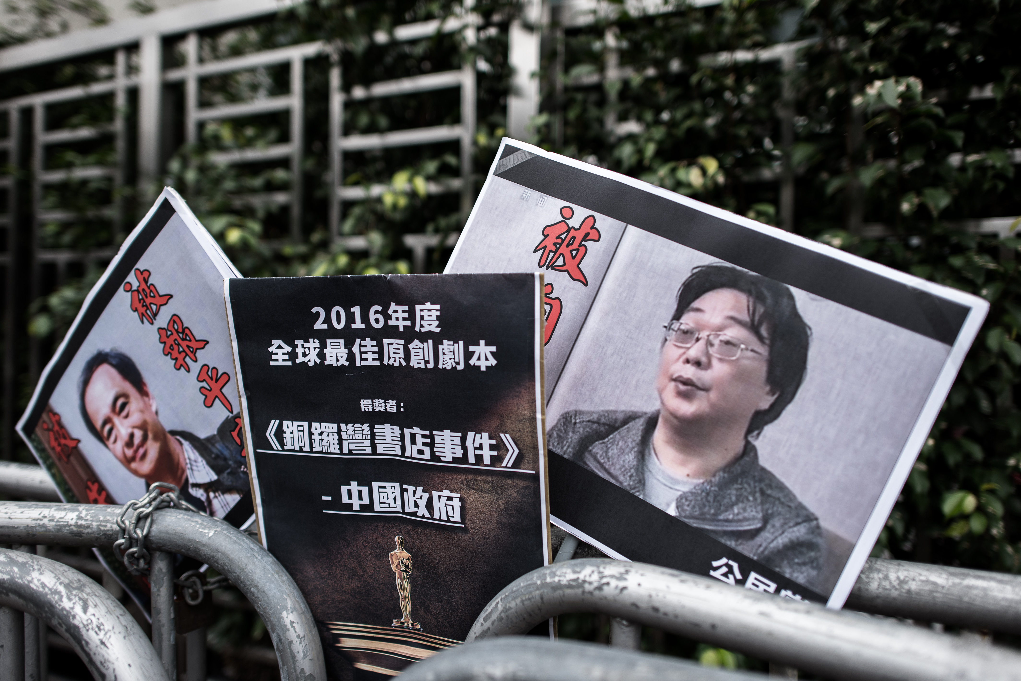 Placards showing missing bookseller Lee Bo (L) and his associate Gui Minhai (R) are seen left by members of the Civic party outside the China liaison office in Hong Kong on January 19, 2016. (PHILIPPE LOPEZ—AFP/Getty Images)