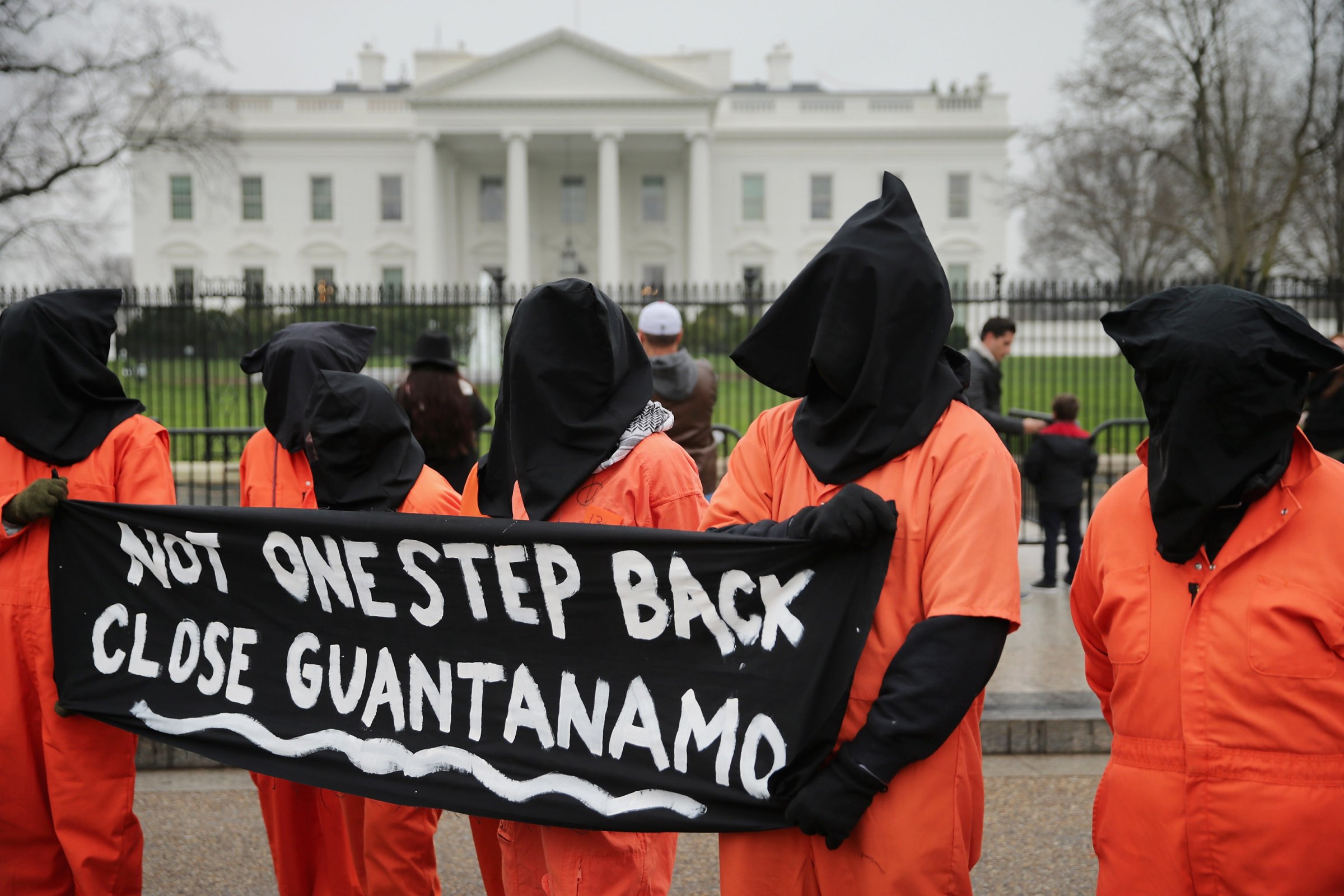 Demonstrators with the group Witness Against Torture dress in orange jumpsuits and wear black hoods while demanding that U.S. President Barack Obama close the military prison in Guantanamo, Cuba, outside the White House in Washington, DC.. on Jan. 8, 2016.