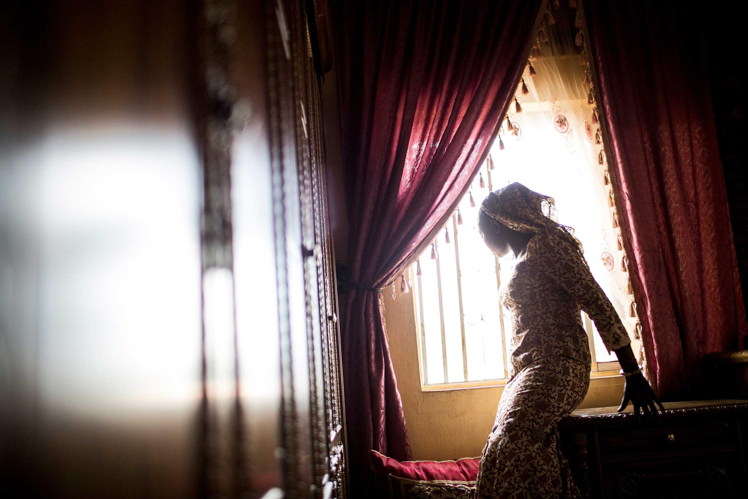A bride looks out the window before her wedding in Kano, Northern Nigeria, Feb. 28, 2014.