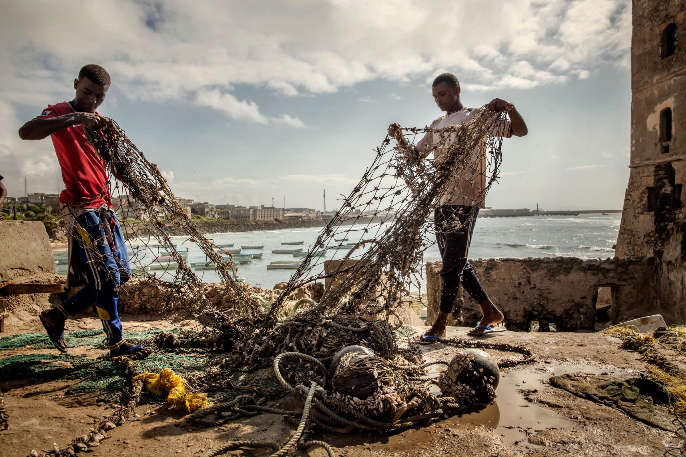 Two sailors to repair sails and mend the fishing nets. The country's waters have been exploited by illegal fisheries and the economic infrastructure that once provided jobs has been ravaged. Mogadishu, Somalia, October 10, 2015.