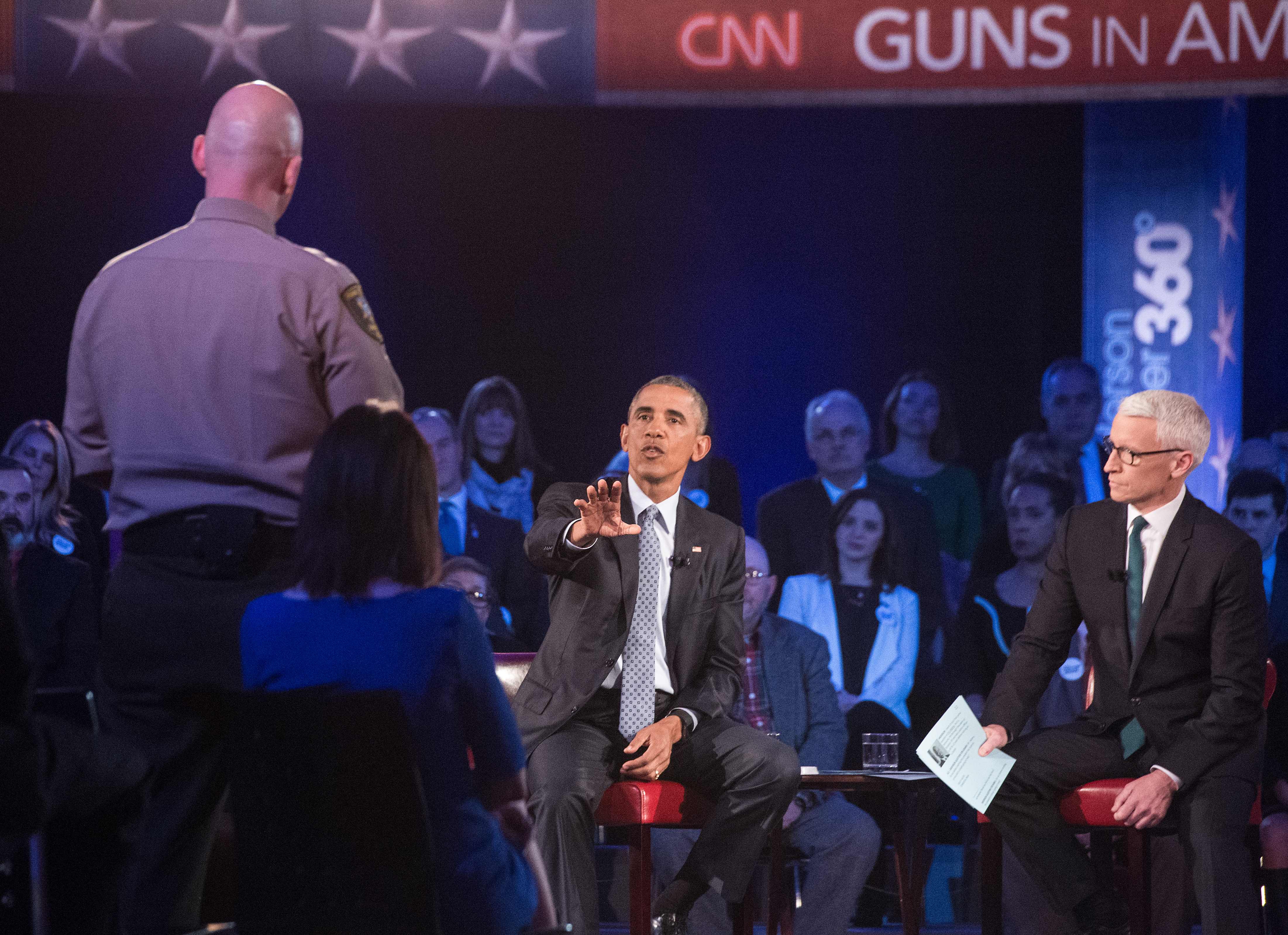 President Barack Obama replies to a question by Arizona Sheriff Paul Babeu (L) at a town hall meeting with CNN's Anderson Cooper (R) on reducing gun violence at George Mason University in Fairfax, Virginia, on January 7, 2016. (NICHOLAS KAMM/AFP/Getty Images)