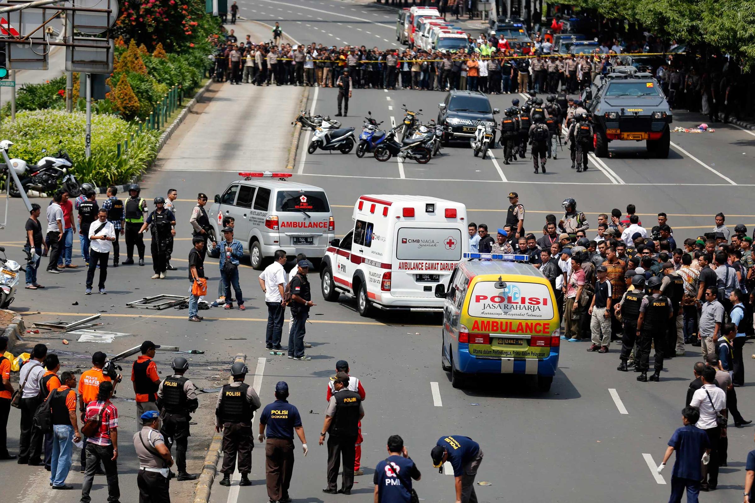 Police ambulances pass the crowds carrying victims to the hospital after a bomb blast in front of a shopping mall in Jakarta, Indonesia, Jan. 14, 2016.