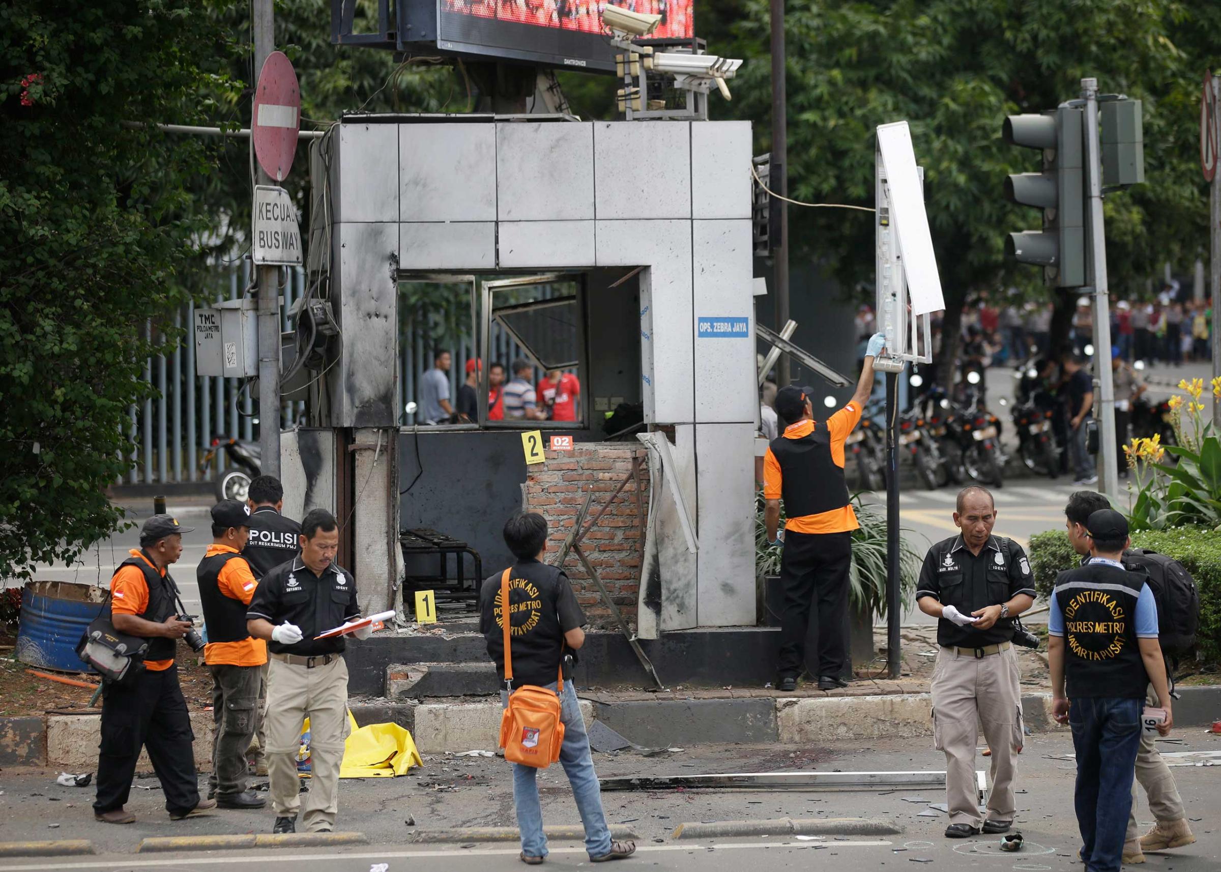 Officers examine a police post where an explosion went off in Jakarta, Indonesia, Jan. 14, 2016. Attackers set off explosions in a bustling shopping area in Indonesia's capital and waged gun battles with police, leaving bodies in the streets as office workers watched from high-rise windows.