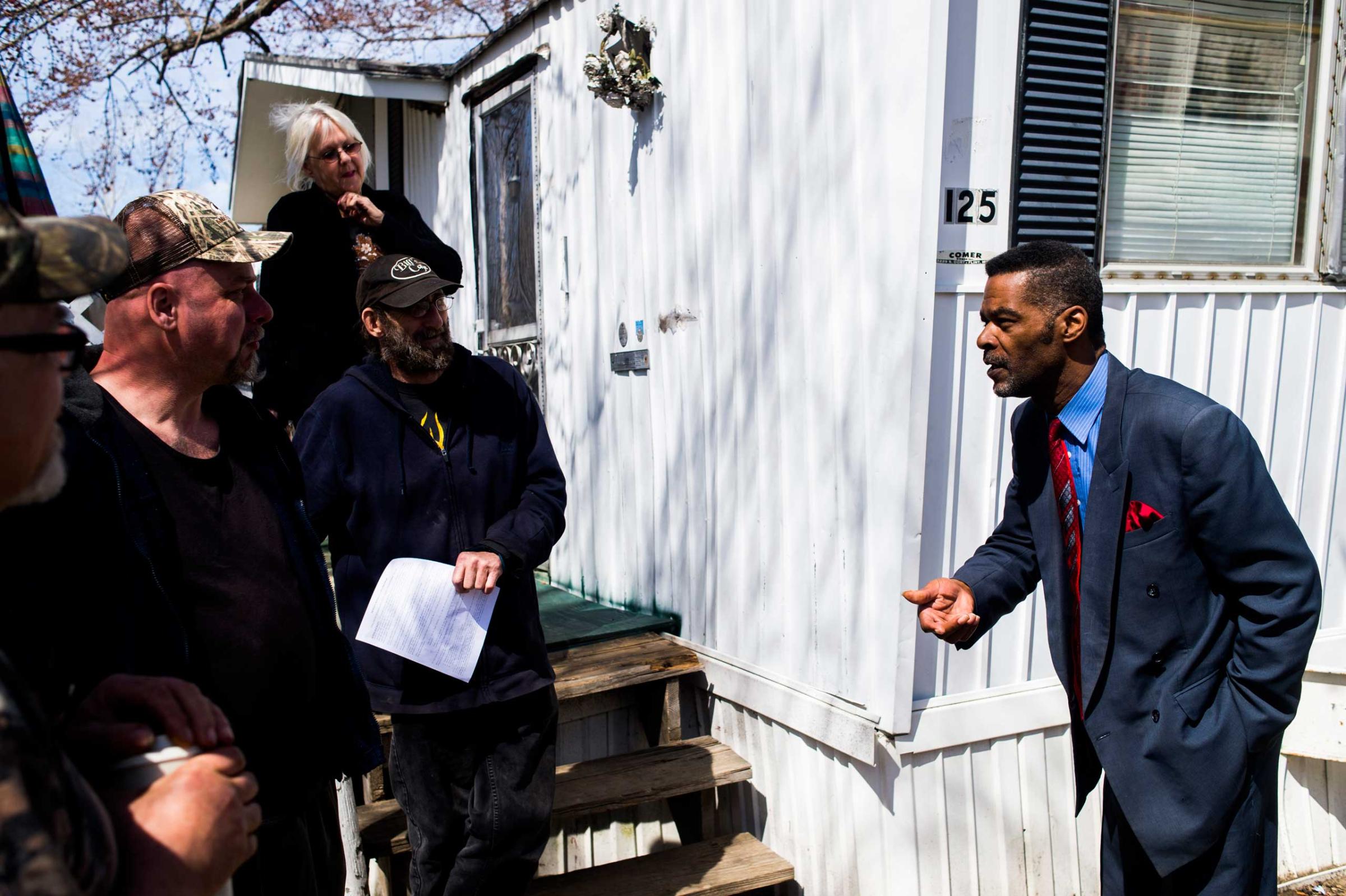 Flint City councilman Eric Mays speaks with concerned residents at Ambassador East mobile home park on April 15, 2015, in Flint, Mich. The city of Flint plans to install a $1.5 million granulated active-charcoal filter by mid-July in an effort to address concerns over its water quality.