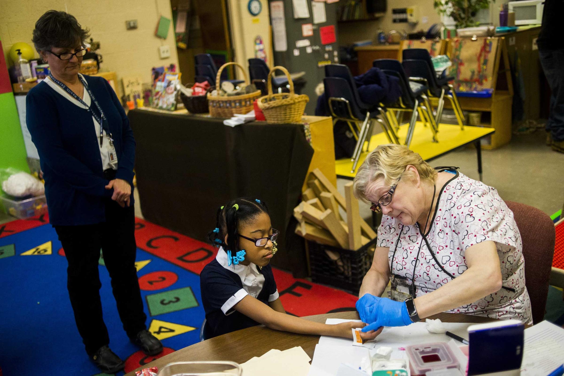 LaShanti Redmond, 10, of Flint, gets her finger poked to test her blood for lead levels at Freeman Elementary School in Flint, Mich., Jan. 12, 2016. The Flint Community Schools, the Genesee County Health Department and Molina Healthcare held a family fun night at the school to get children ages 0 to 6-year-olds tested for lead levels in their blood. The next testing event will be held at Eisenhower Elementary on Jan. 26.
