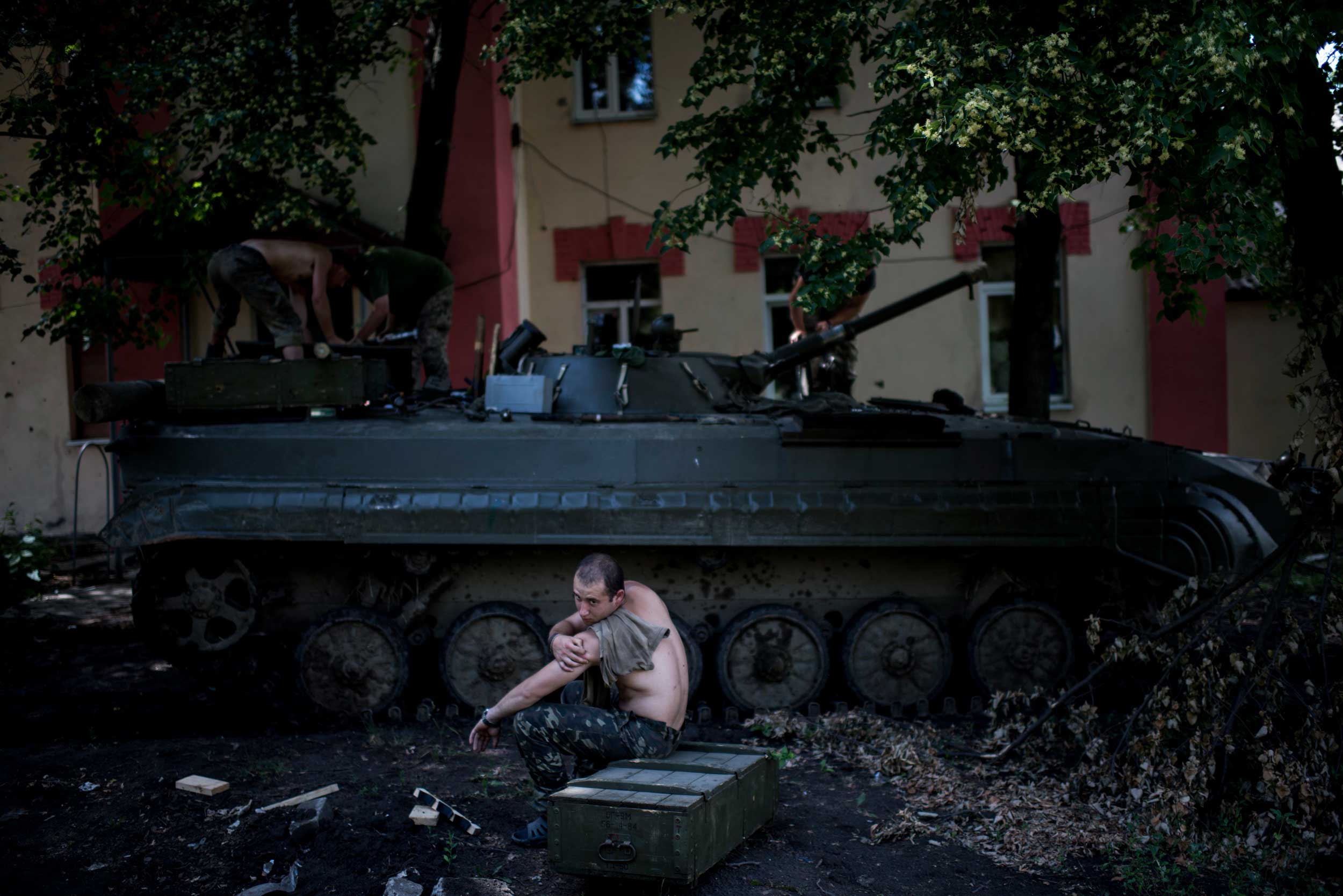 A Ukrainian serviceman rests after loading ammunition to an armoured personnel carrier (APC) in position in Krymske village, Luhansk region, eastern Ukraine, June 20, 2015.