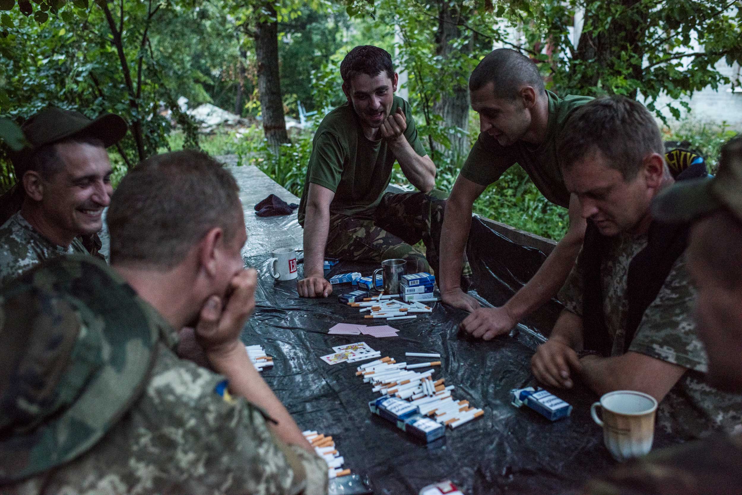 Ukrainian government soldiers playing cards over cigarettes at the frontline in Krymske village, Luhansk region, eastern Ukraine, June 20, 2015.