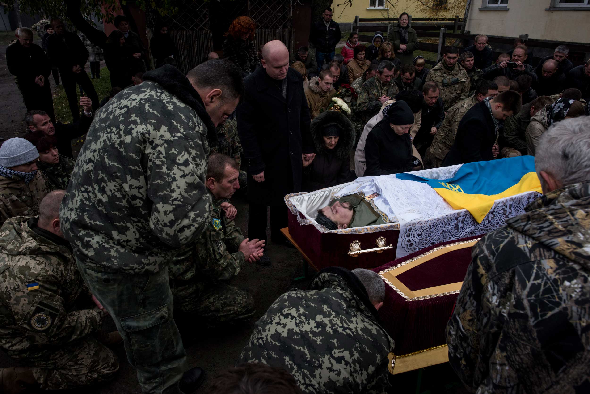 Relatives and comrades say their last goodbye to Ukrainian serviceman Vitaliy Kravchenko, whose body is in the coffin. He was killed by a mine explosion near Avdiivka, during a commemoration ceremony in Rava-Russkya, western Ukraine, Nov. 5, 2016.