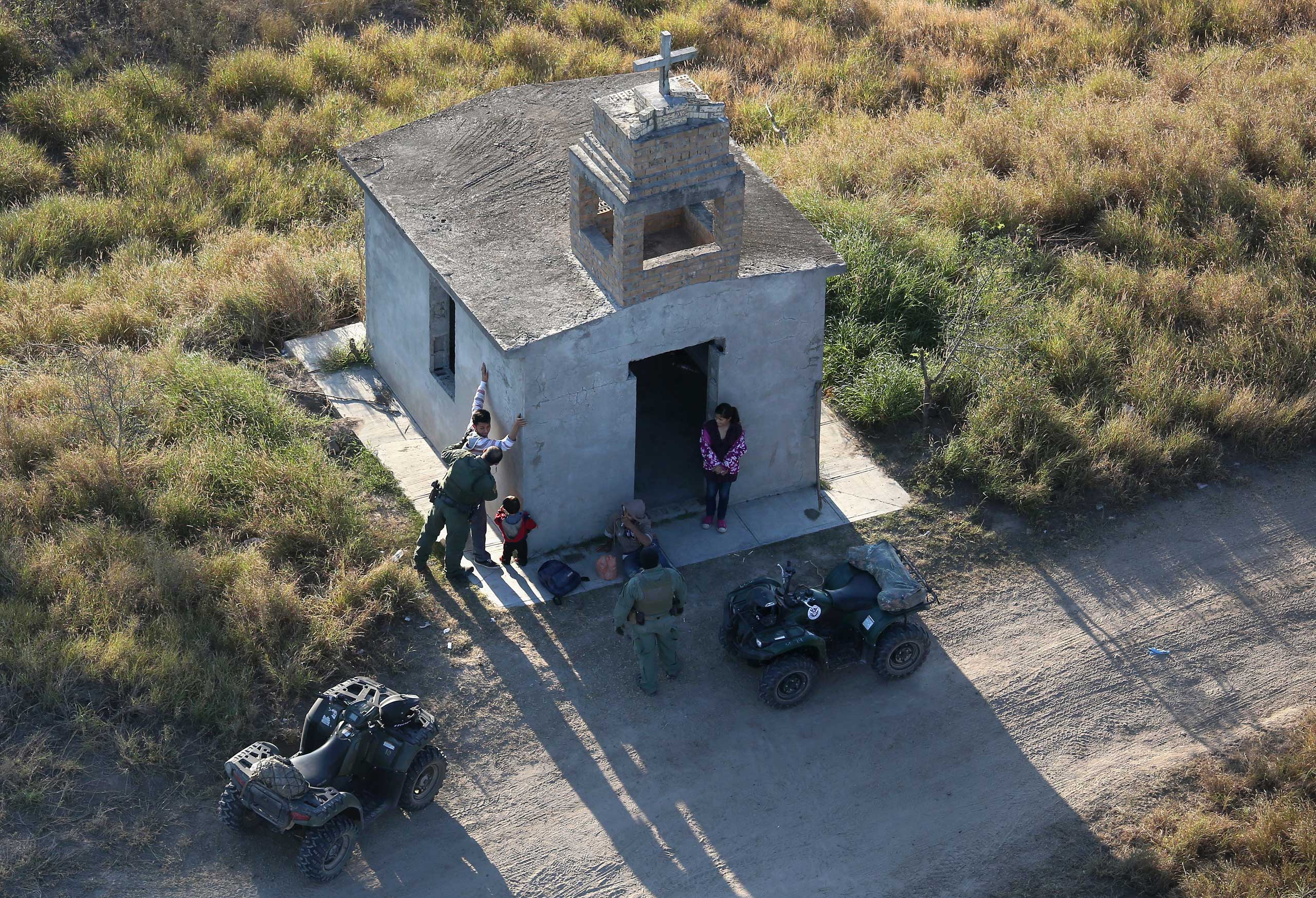 U.S. Border Patrol agents search a migrant family after they crossed the U.S.-Mexico border near Rio Grande City, Texas, on Dec. 9, 2015. (John Moore—Getty Images)