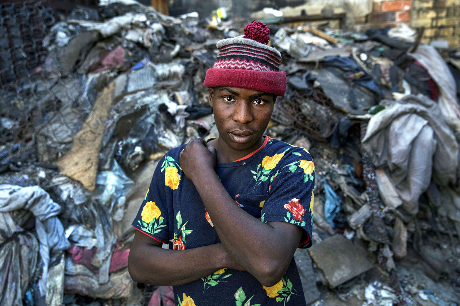 Pumulelo (age 25 ) a migrant from Zimbabwe stands in the piles of rubbish at a derelict building he has made his home, July 19, 2015.
