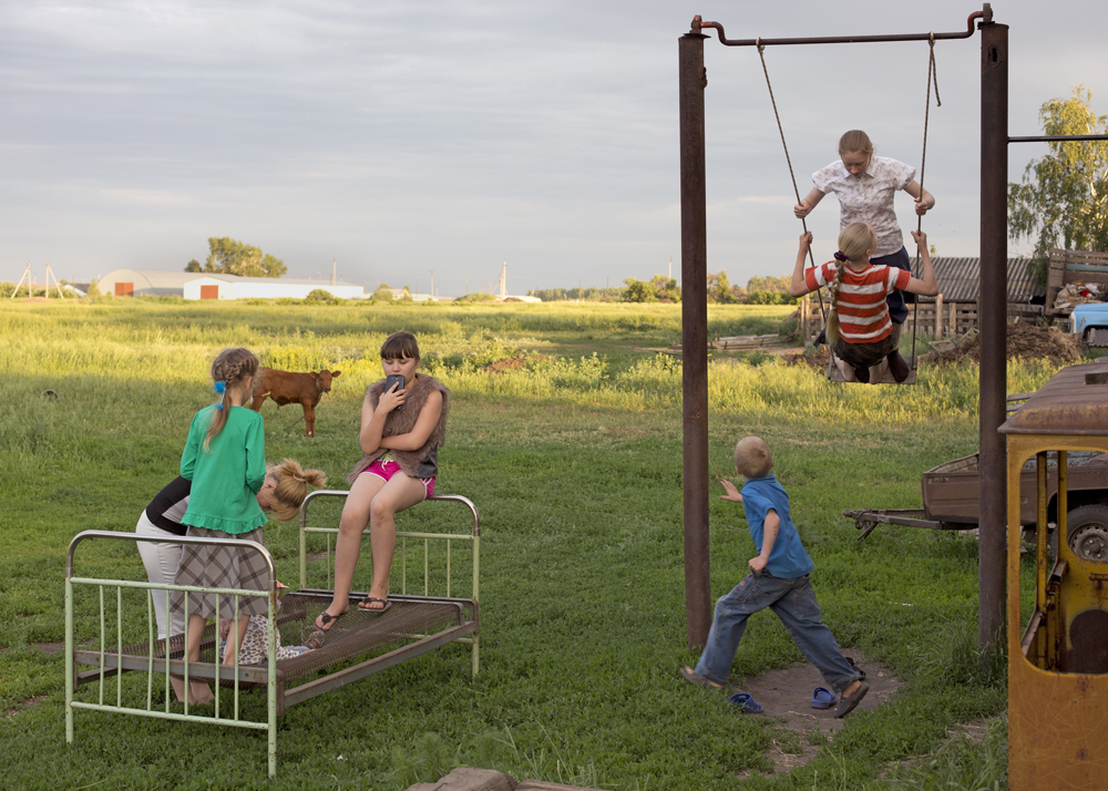 Siblings play with their Russian neighbors in the backyard in Pertrovka, Russia, 2014.