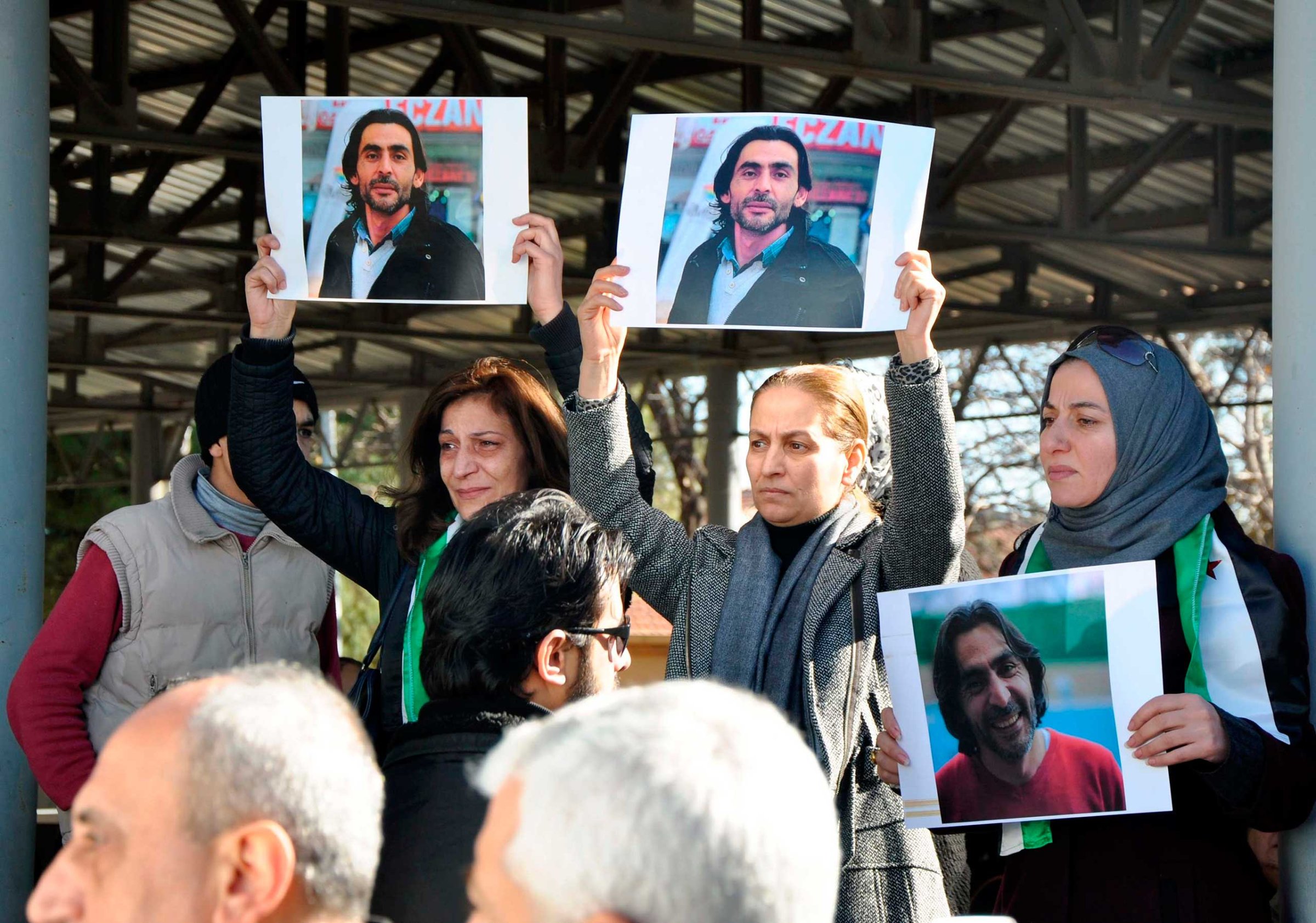 Women hold pictures of film maker Naji Jerf, a citizen journalist with the anti-ISIS activist group Raqqa is Being Slaughtered Silently, who was killed Dec. 27 in Gaziantep, Turkey, on Dec. 28, 2015.