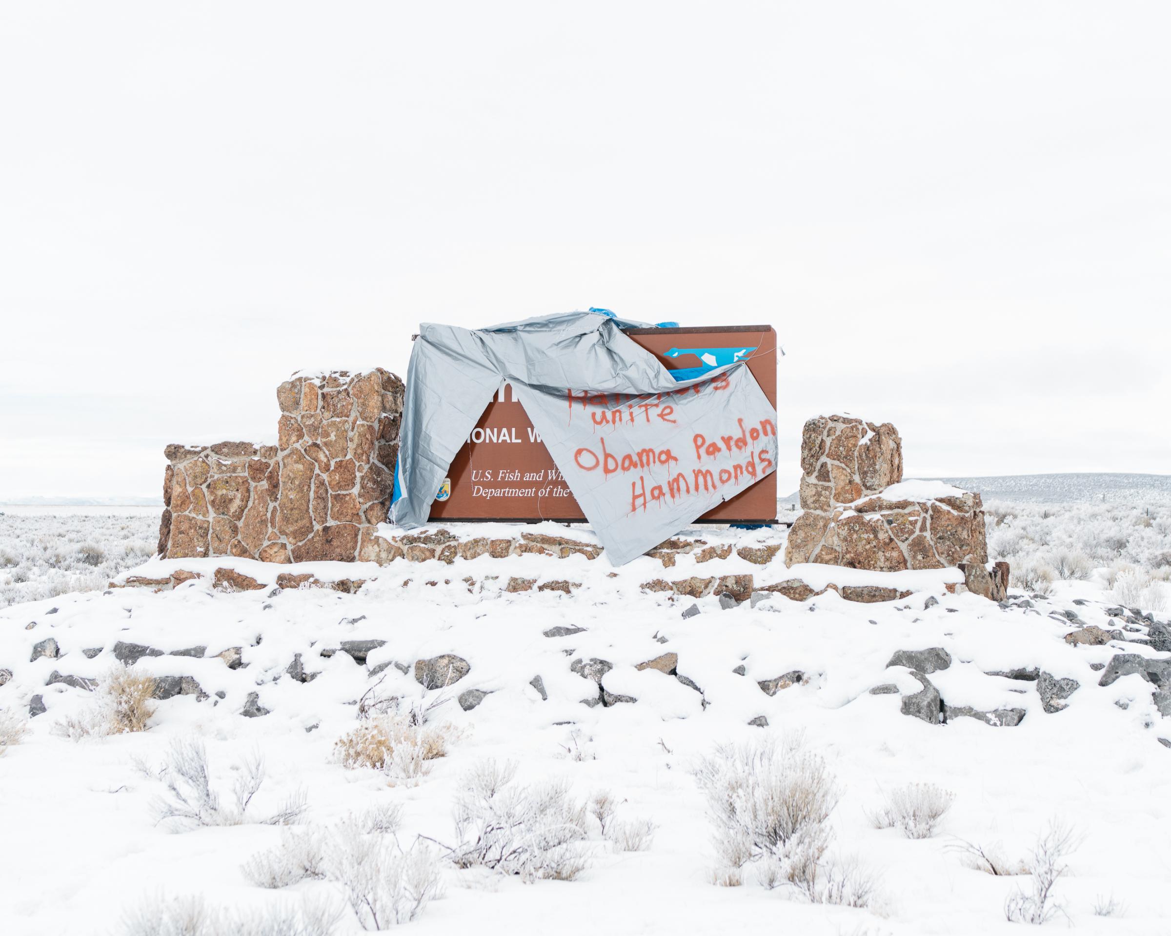 A sign for the Malheur National Wildlife Refuge along Frenchglenn Highway is draped with a tarp that reads "Ranchers Unite, Obama Pardon Hammonds" on Jan. 11, 2016.