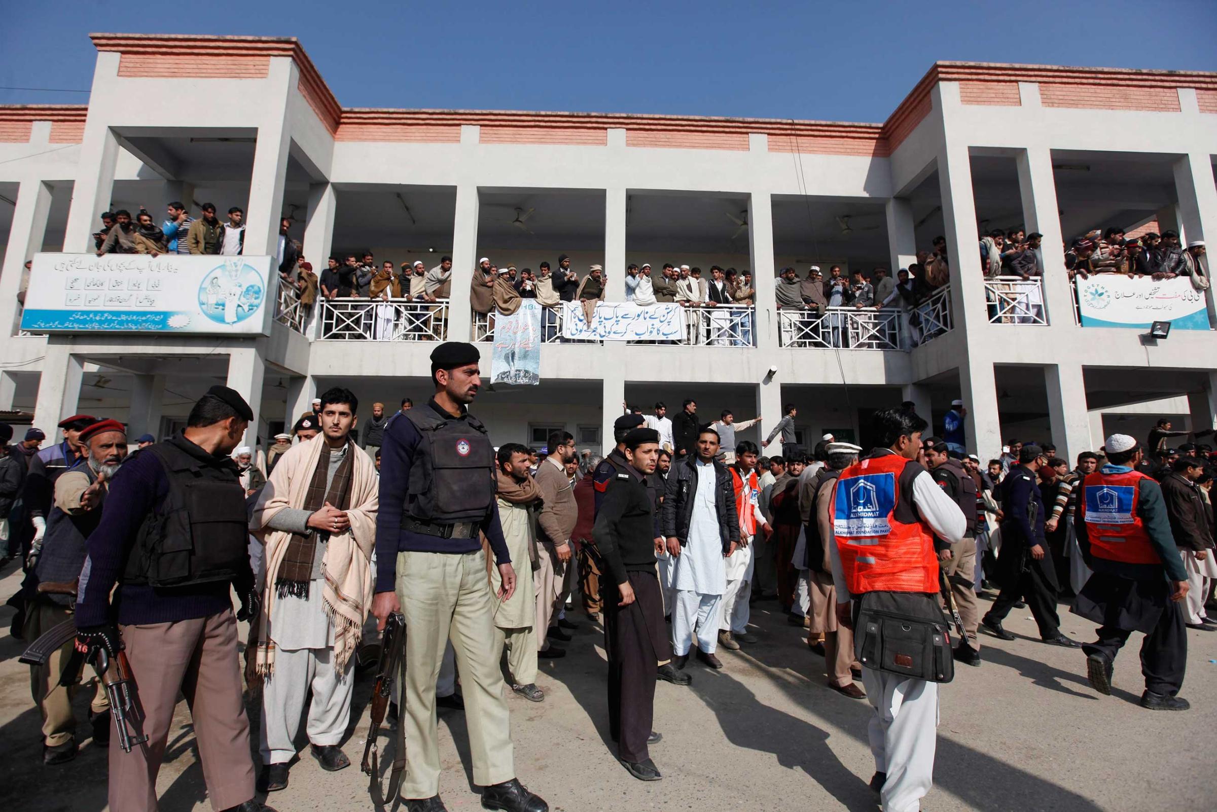 Security officials, rescue workers and relatives gather outside the hospital after gunmen attacked Bacha Khan University, in Charsadda, northwest Pakistan, Jan. 20, 2016.