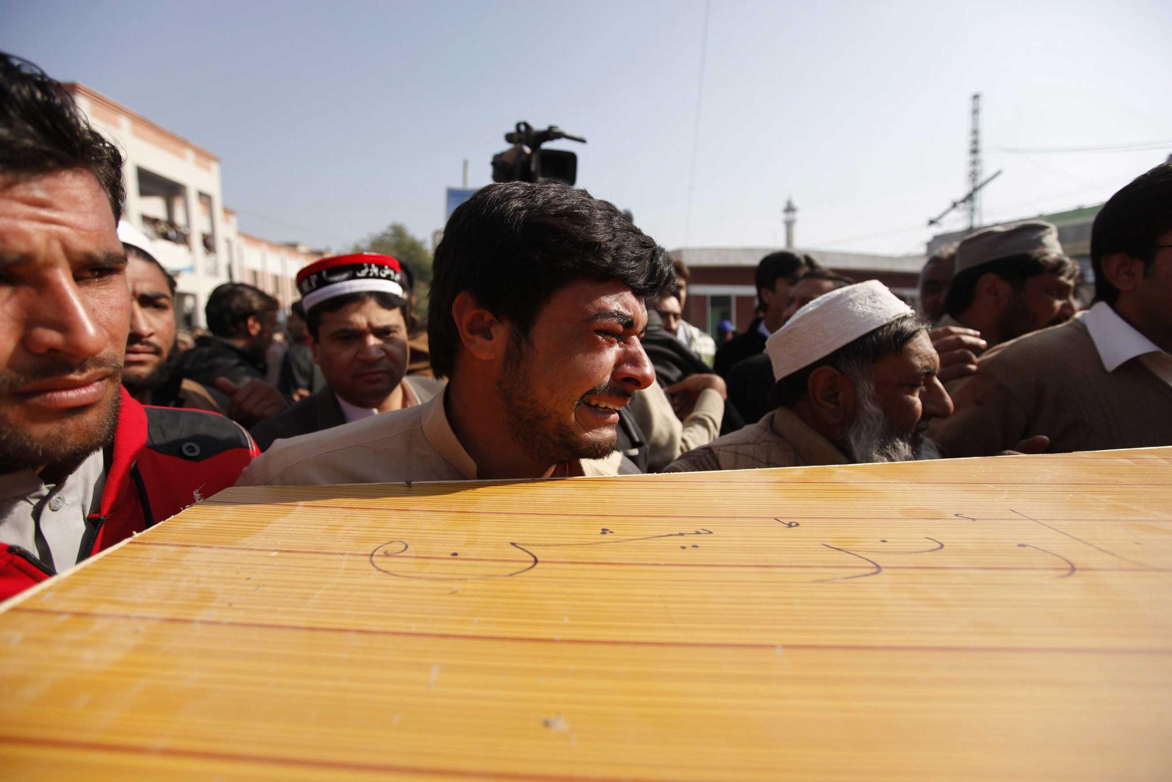 A man cries as he helps to carry the body of a victim of the attack on Bacha Khan University from a hospital in Charsadda, Pakistan, Jan. 20, 2016.