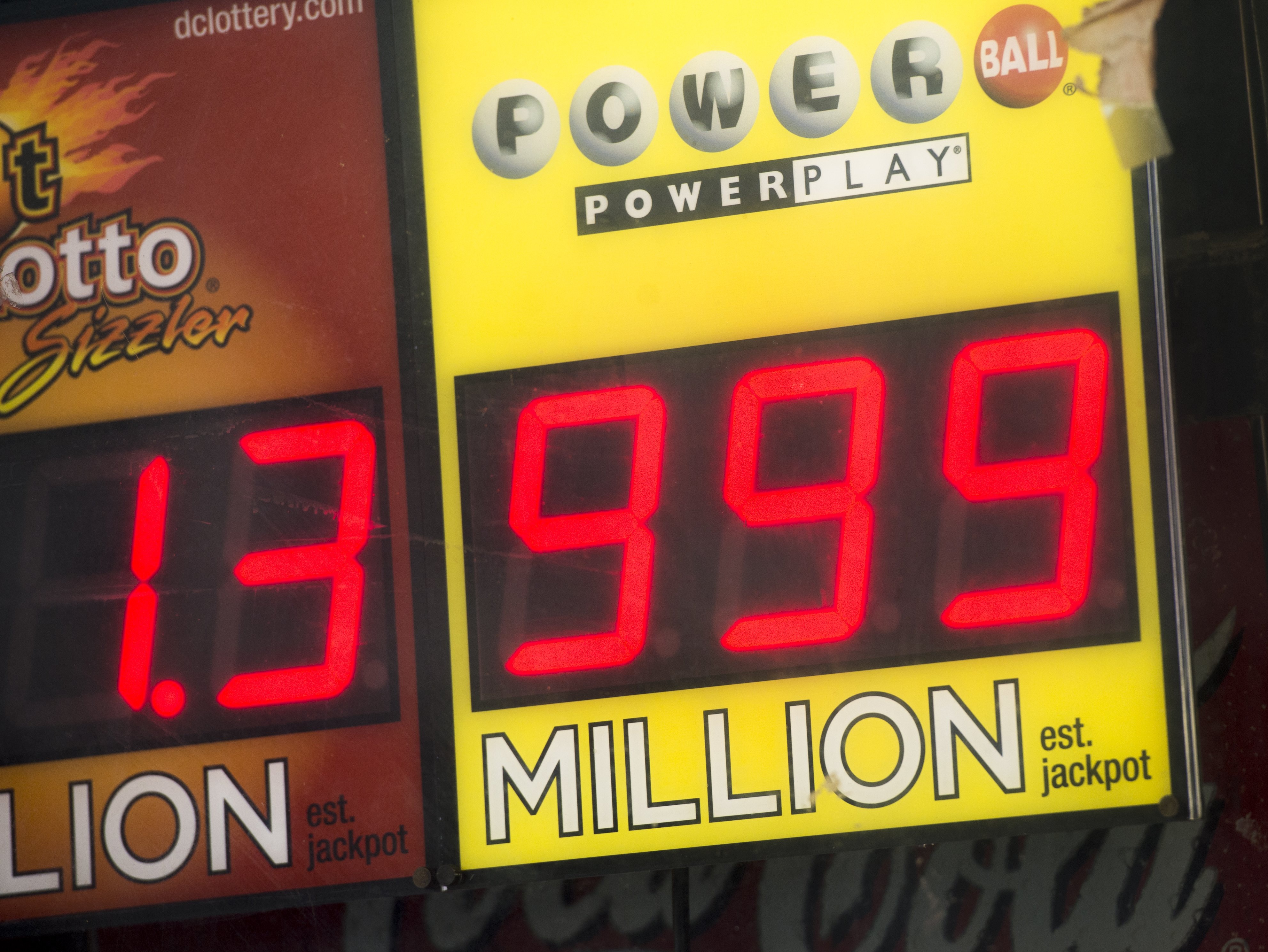 A sign showing a Powerball prize of $999 million, the largest jackpot winnings that the Powerball sign can display, with the actual Powerball jackpot estimated at $1.3 billion, outside a deli in Washington, DC on Jan 11. (Saul Loeb—AFP/Getty Images)