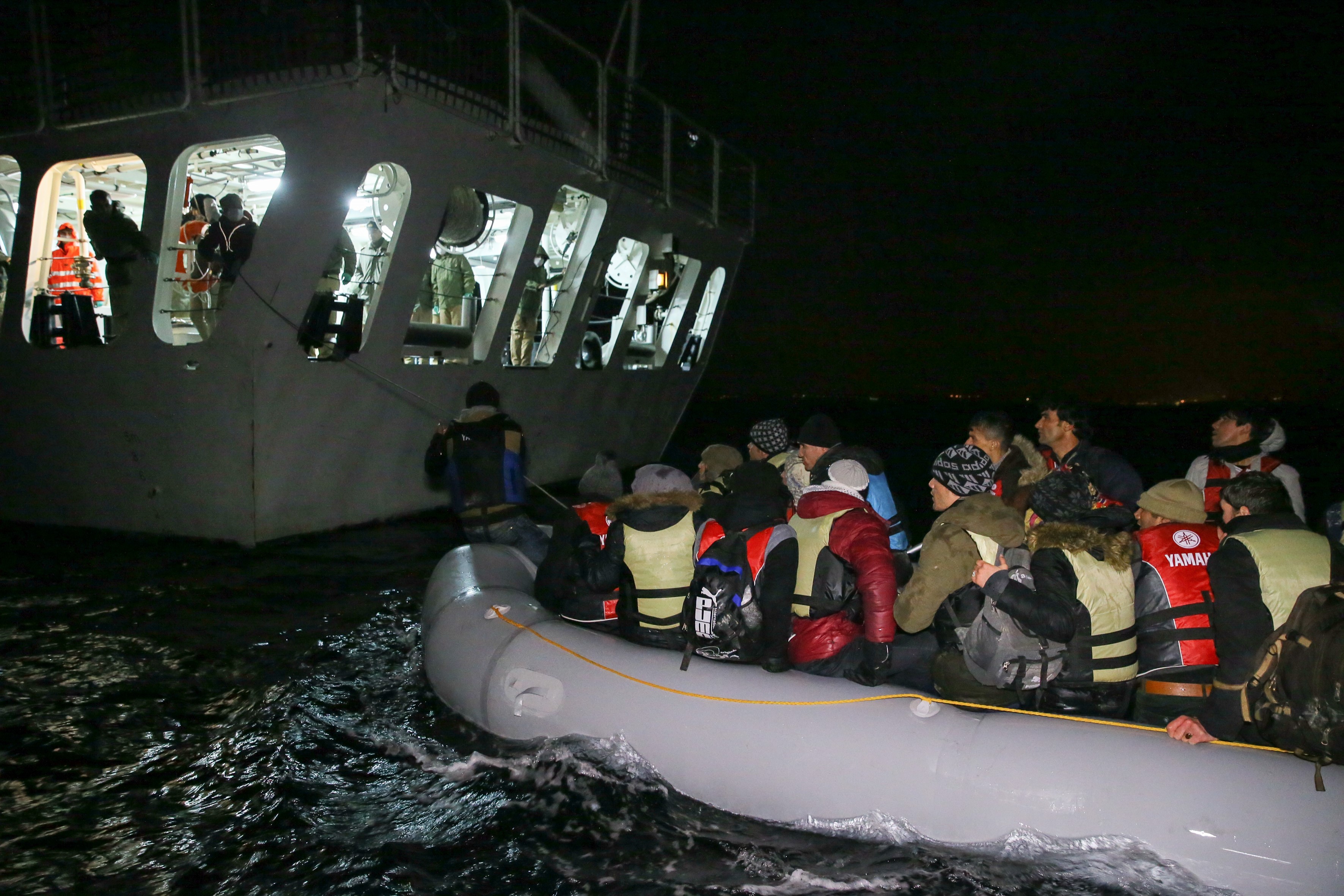 Turkish coast guards pull a refugee boat into a Turkish Coast Guard ship during a rescue operation for the asylum seeker refugees who were illegally trying to reach Greece through the Aegean Sea with a overloaded inflatable boat, on the shores of Turkey's Izmir Province's Cesme District on Jan. 21, 2016. (Anadolu Agency‚Getty Images)