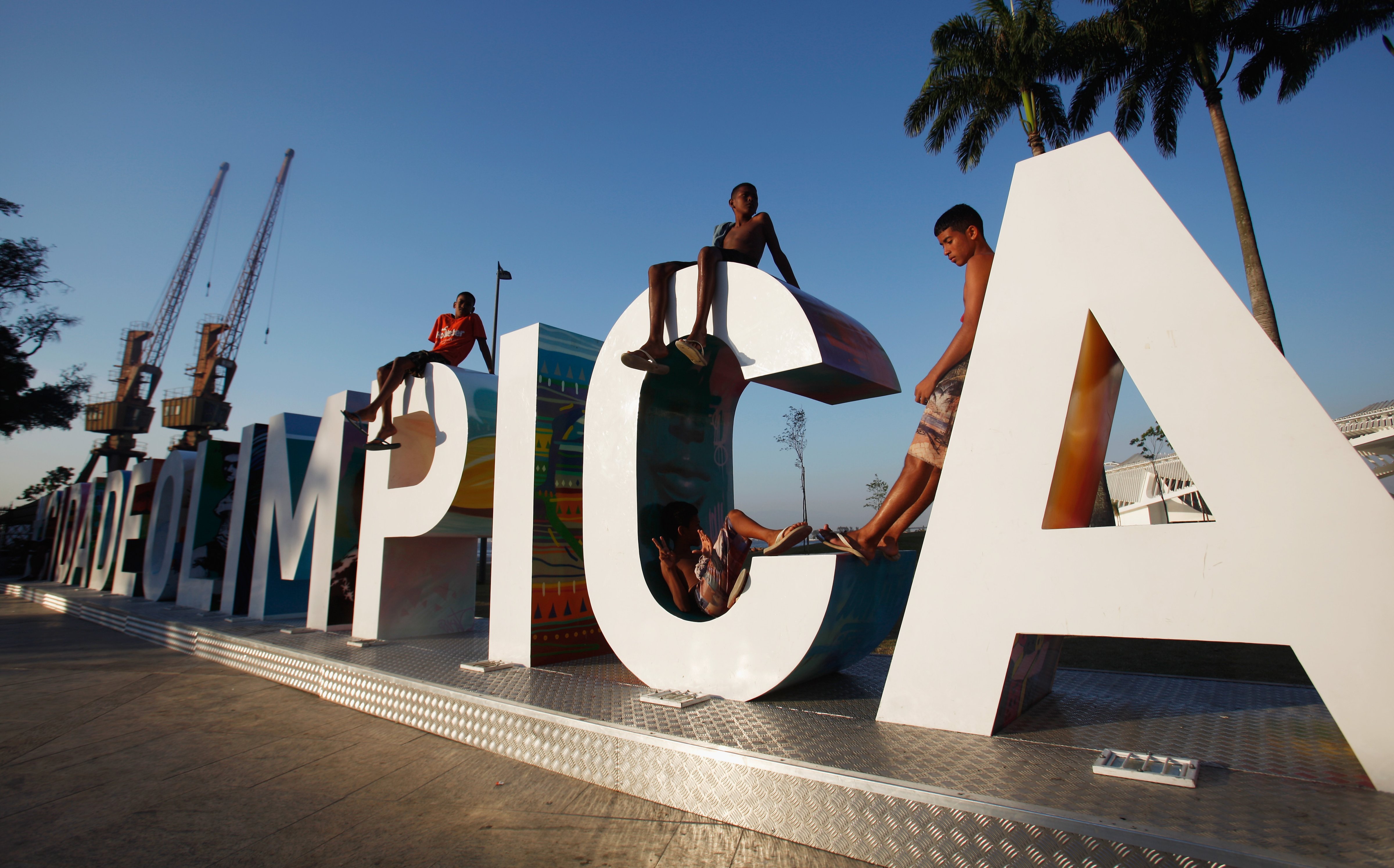Teens sit on a new sign reading 'Cidade Olimpica' (Olympic City) in the historic port district in Rio de Janeiro, Brazil on Oct. 15, 2015. (Mario Tama—Getty Images)