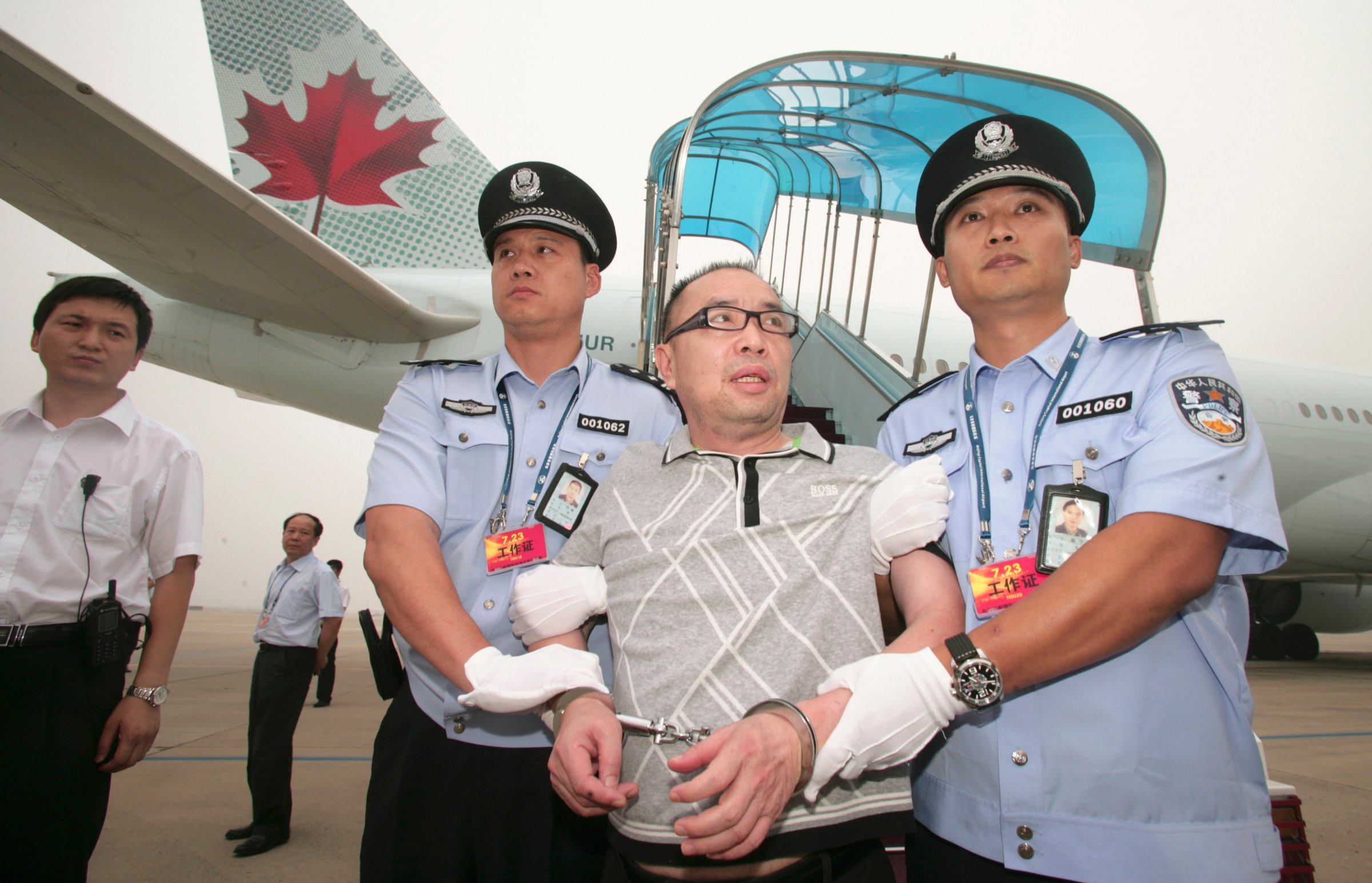 Then Chinese fugitive Lai Changxing is escorted back to Beijing from Canada, at Beijing International Airport
