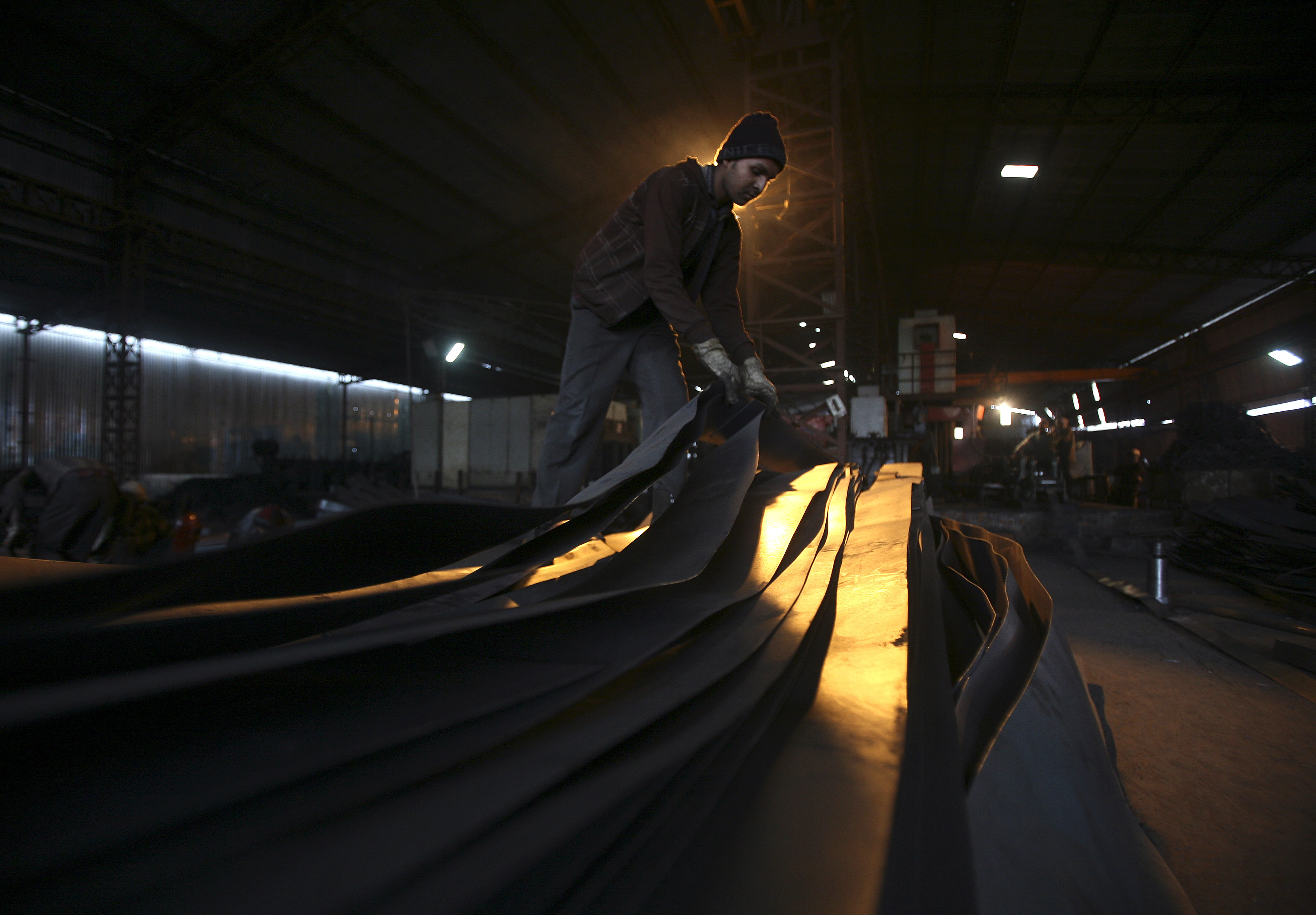 An employee works inside an iron factory on the outskirts of Jammu