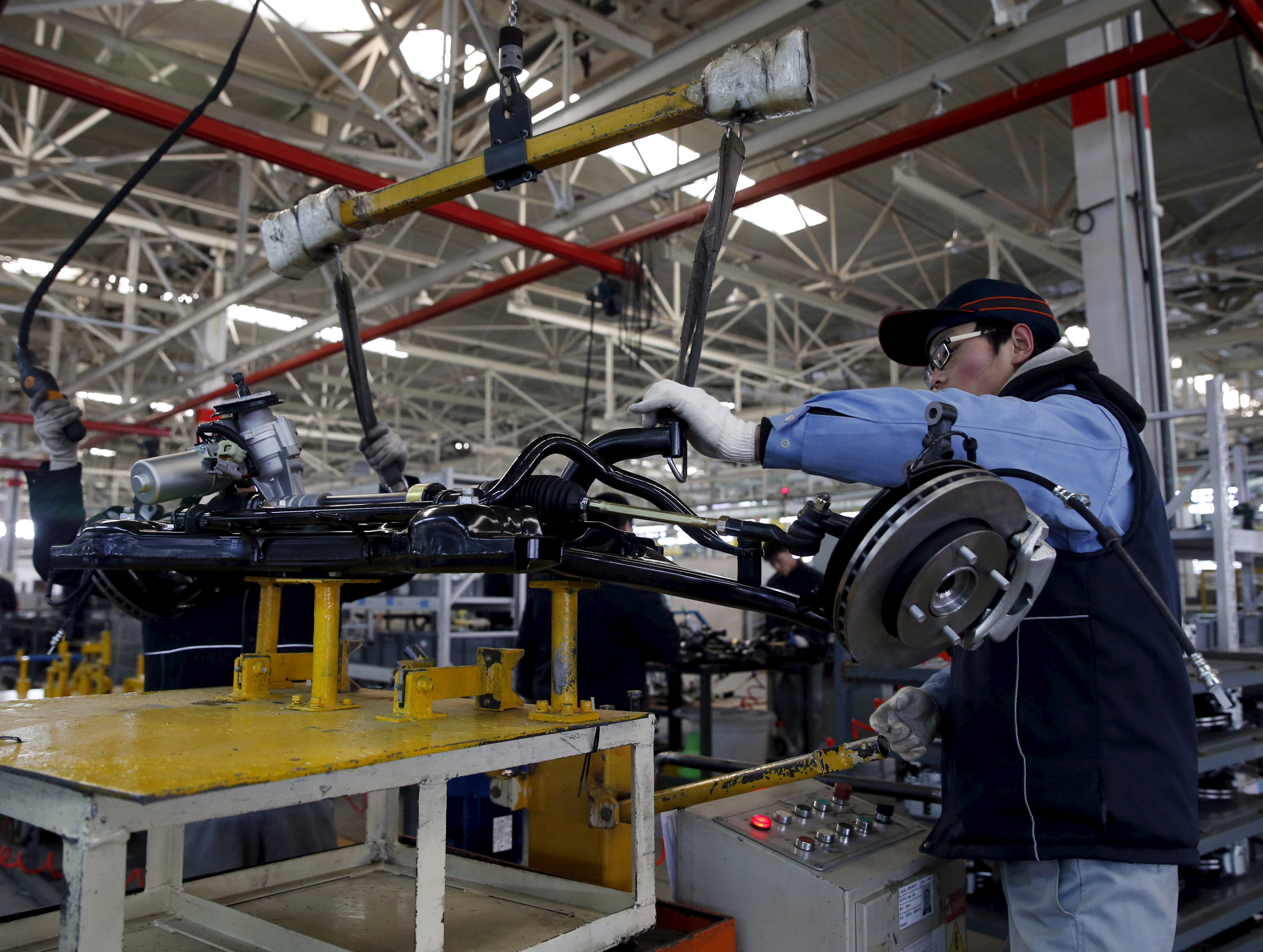An employee works on an assembly line producing electronic cars at a factory of Beijing Electric Vehicle, funded by BAIC Group, in Beijing, China, Jan. 18, 2016. (Kim Kyung Hoon—Reuters)