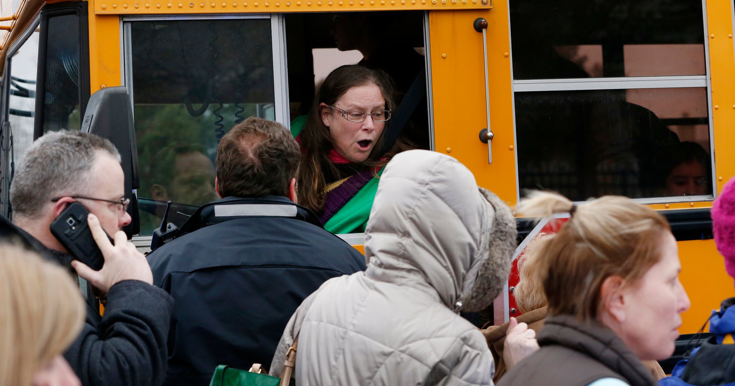A school bus driver yells to a parent that their child is safe after a bus accident at Amy Beverland Elementary School that left several students injured and one adult dead on school grounds on Jan. 26, 2016 in Indianapolis, Ind.