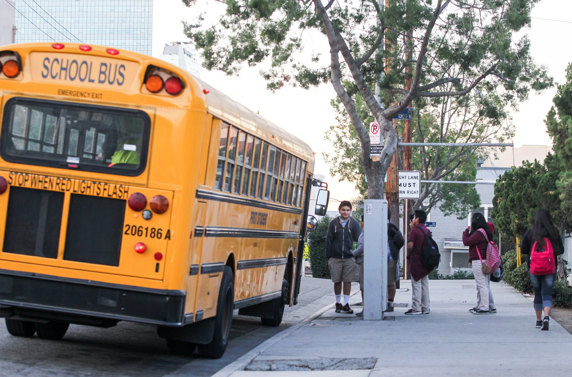 Students line up for a school bus outside a school in Los Angeles on December 16, 2015.