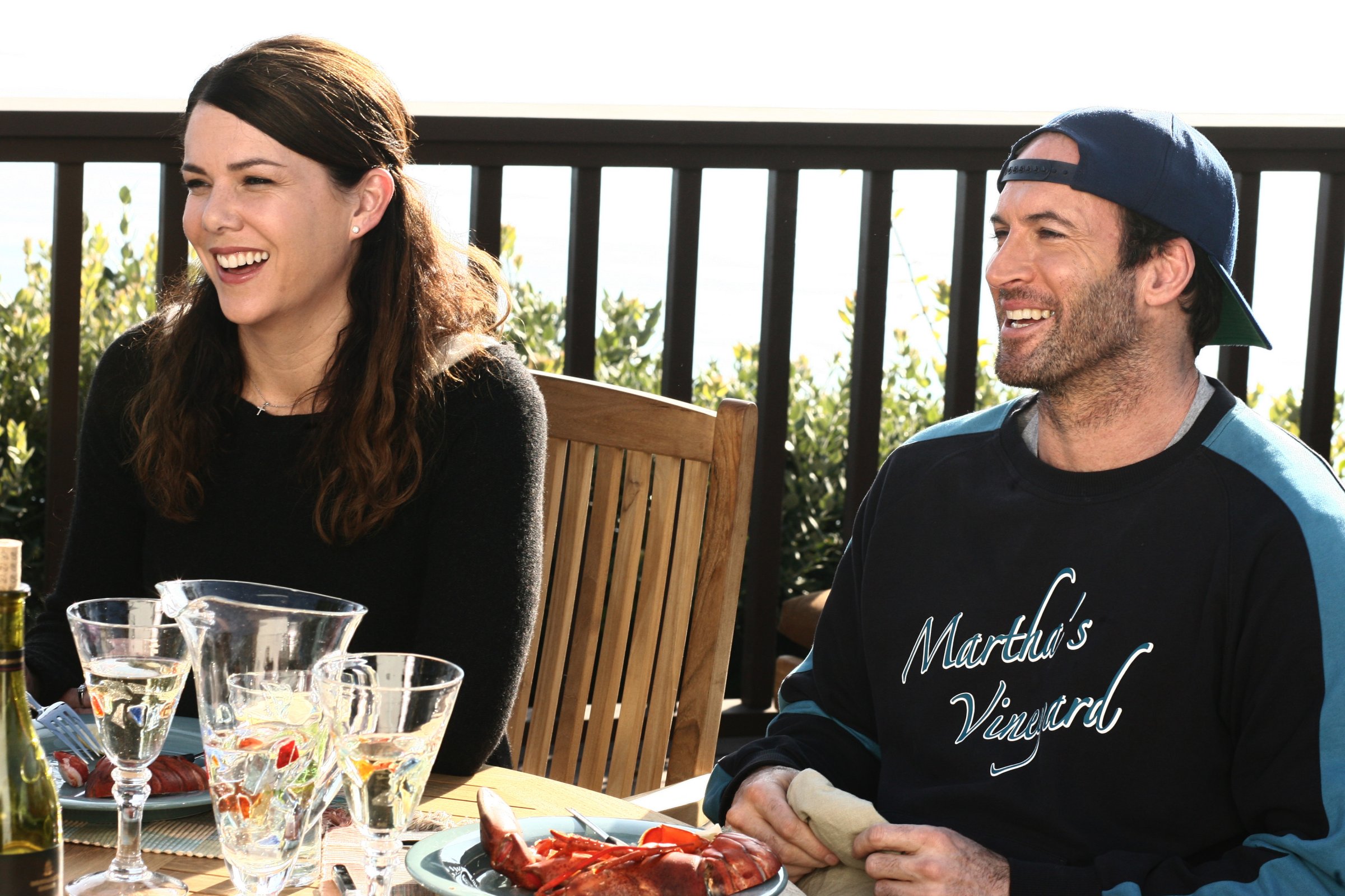 Medium shot of Lauren Graham as Lorelai sitting at patio dining table with Scott Patterson as Luke.