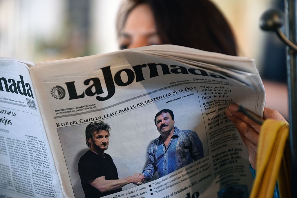 A woman reads La Jornada newspaper in Mexico City on Jan. 10, 2016, which shows a picture of drug lord Joaquin Guzman, aka "El Chapo" (R), shaking hands with Sean Penn. (ALFREDO ESTRELLA-AFP/Getty Images)