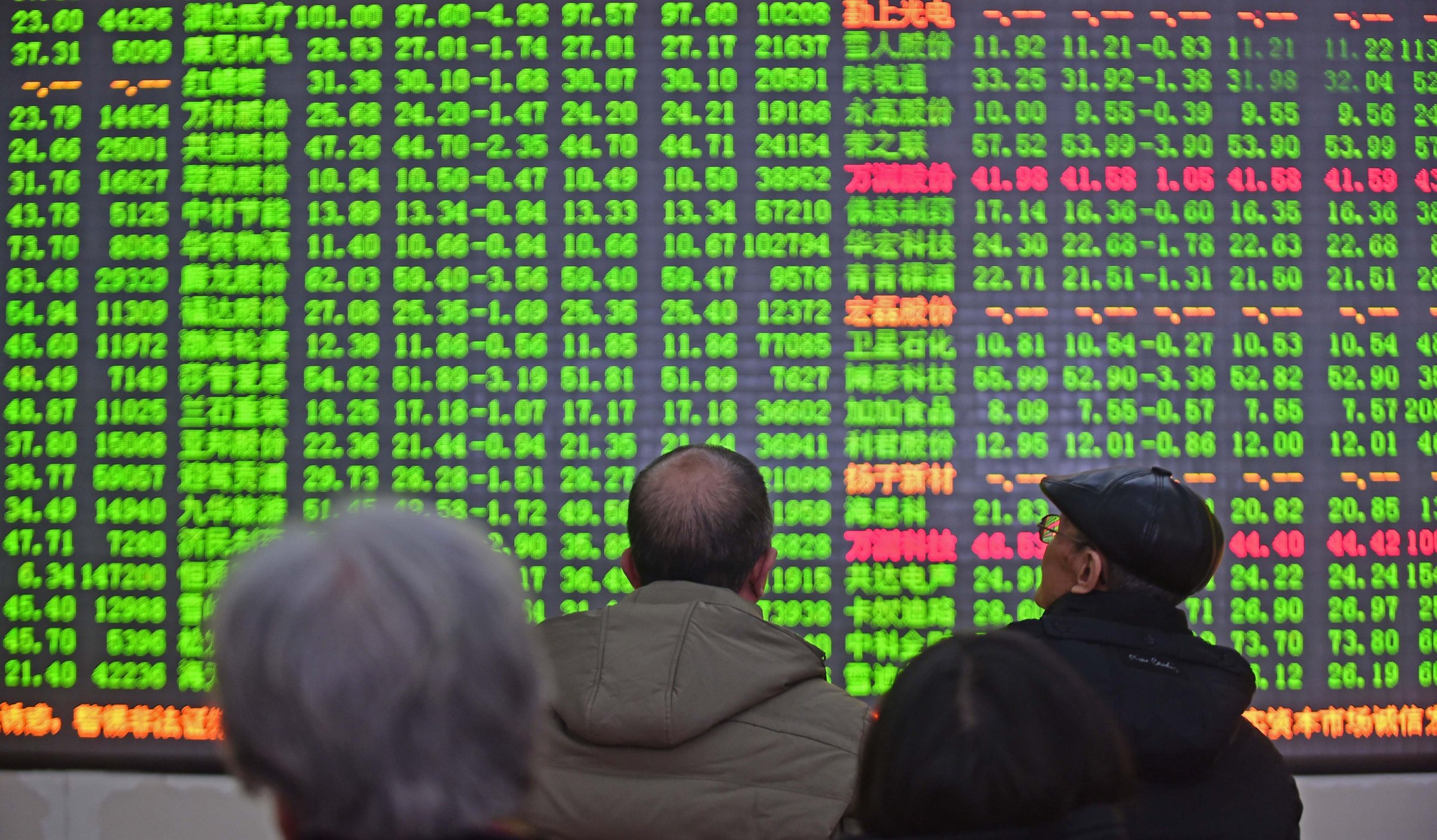 Investors look through stock information at a trading hall in Shenyang, China on Jan. 4, 2016.