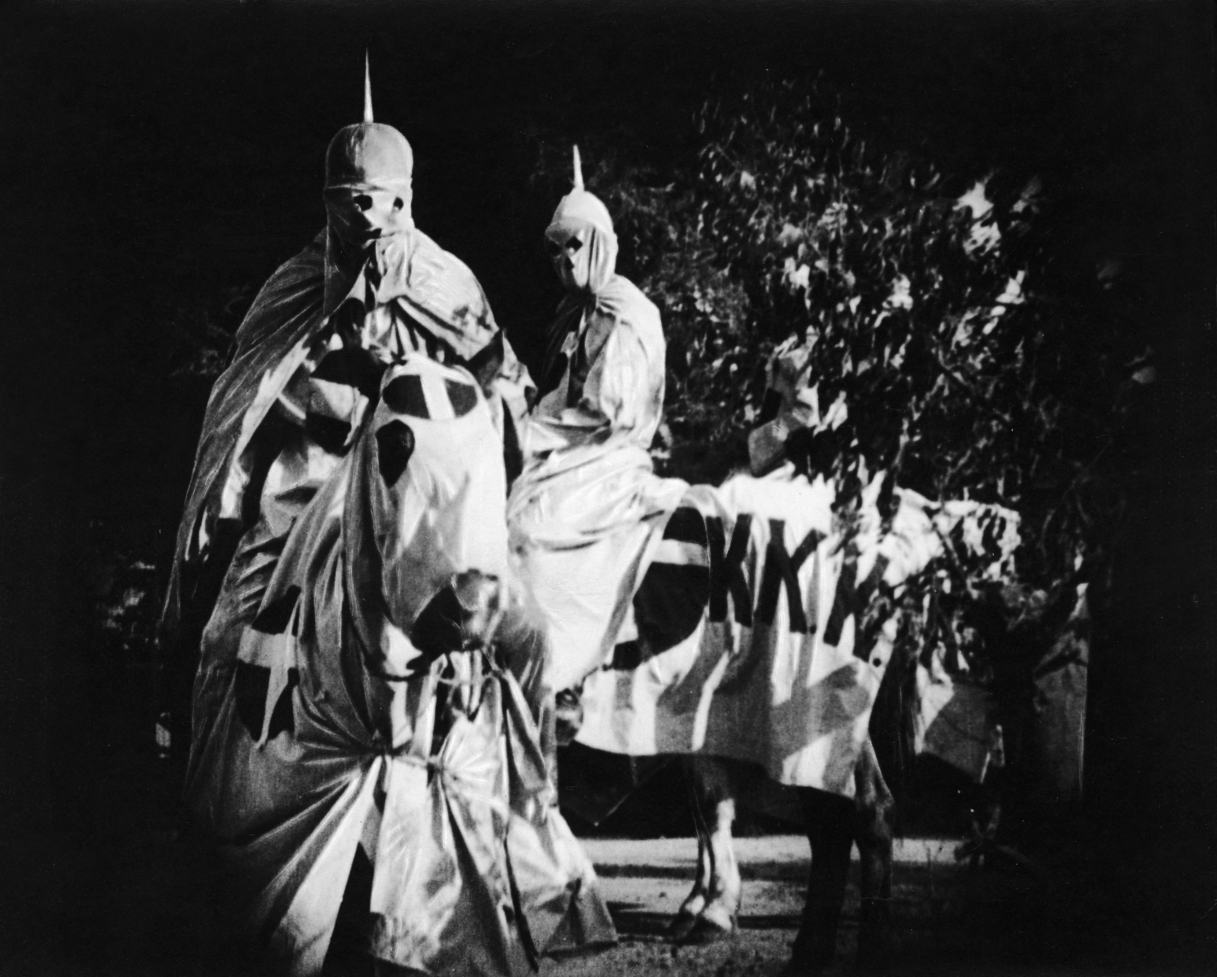 Actors costumed in the full regalia of the Ku Klux Klan ride on horses at night in a still from the 'The Birth of a Nation,' directed by D. W. Griffith, California, 1914. (Hulton Archive/Getty Images)