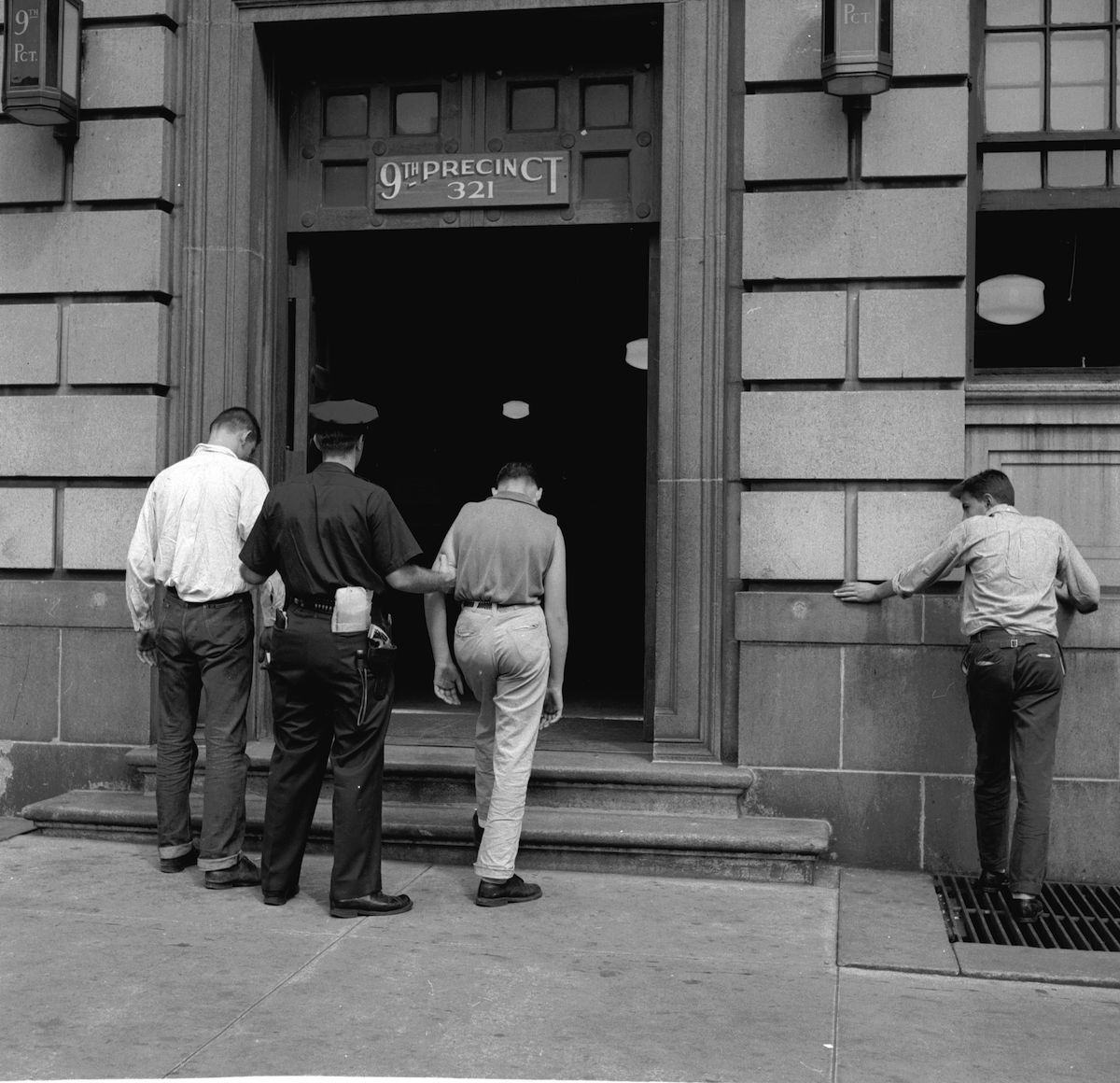 circa 1955:  Two members of a teenage street gang are taken into the 9th Precinct police station after their arrest in New York City. (Carl Purcell&mdash;Getty Images)