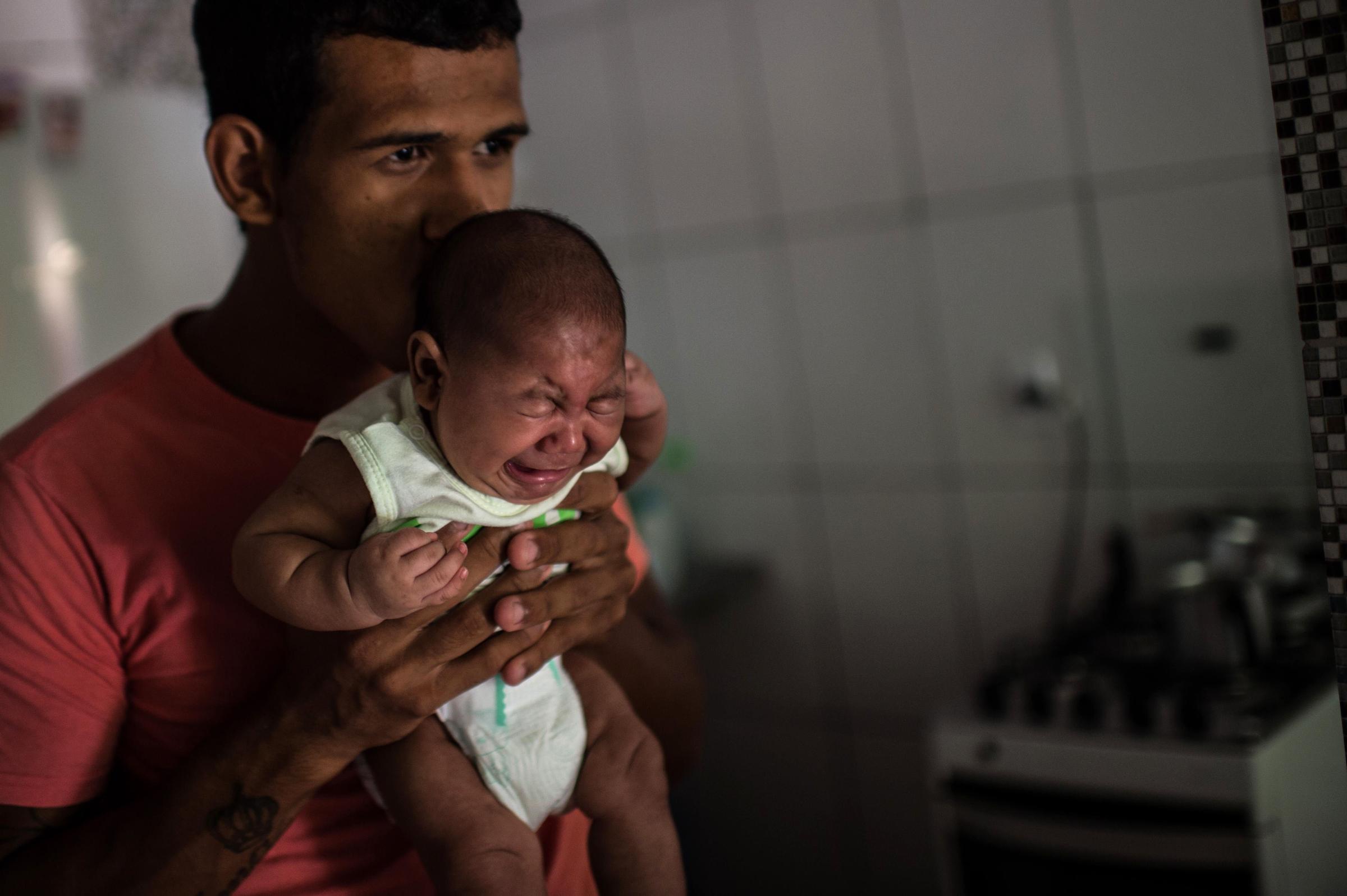 Matheus Lima, 22, holds his two-year-old son, Pietro, who suffers from microcephaly, at his home in Salvador, Brazil, Jan. 28 , 2016.