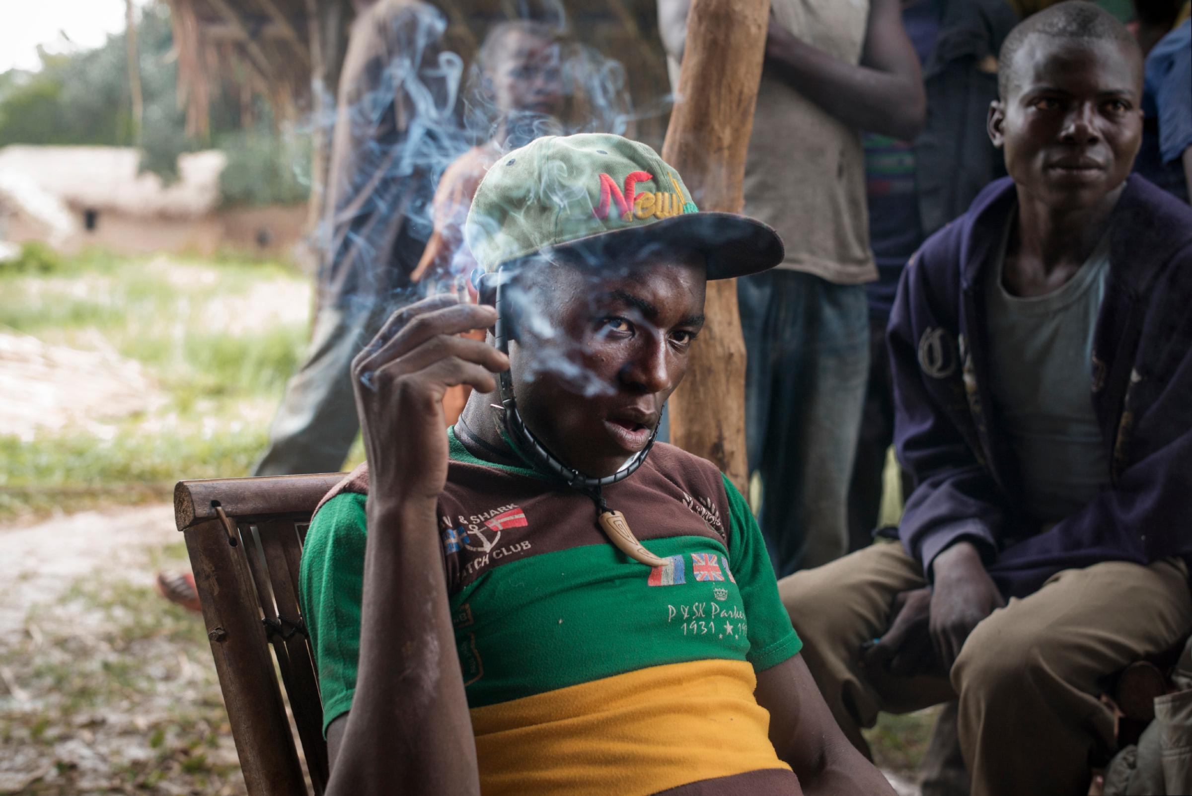 A leader of an antibalaka militia group, Pelé, smokes a cigarette in the village of Balakadja, Central African Republic, on Aug. 4, 2015.