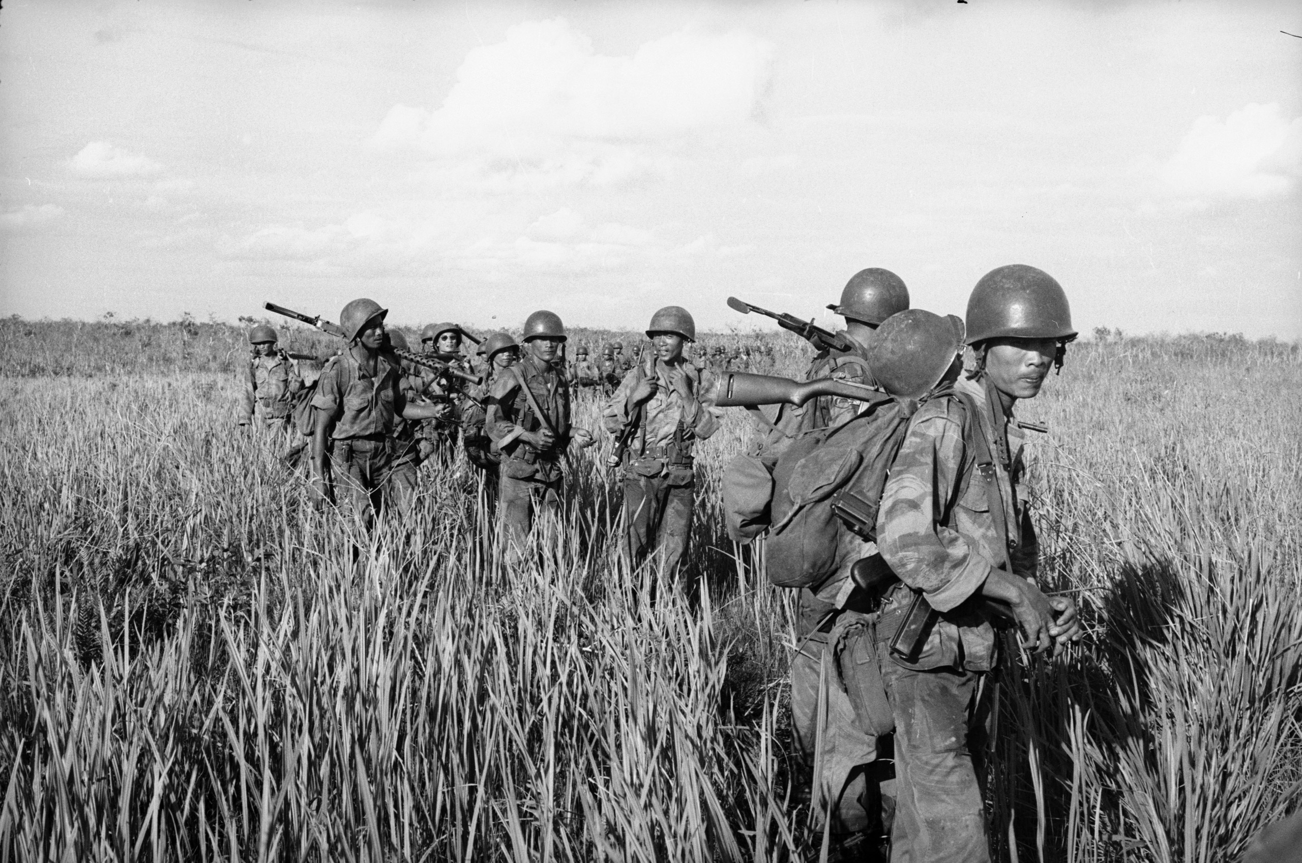 Vietnamese troops move through razor grass field, ca. 1961-65.
