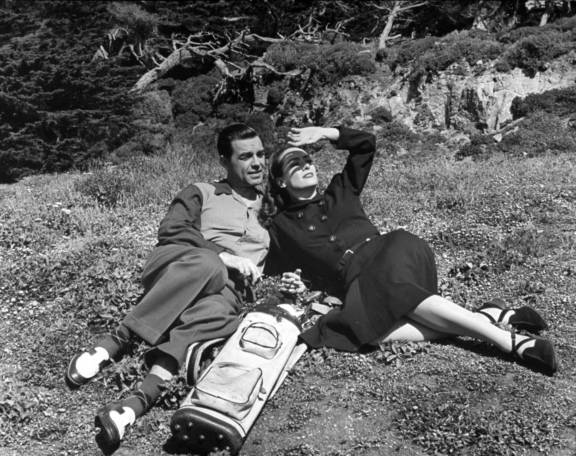 Joan Crawford and her husband, Philip Terry, relaxing during golf game. 1945.