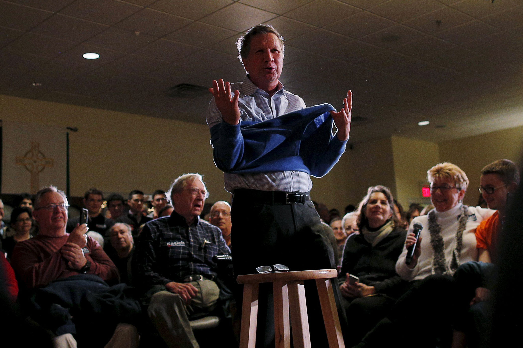 Republican presidential candidate, Ohio Gov. John Kasich takes off his sweater during a campaign town hall meeting in Worcester, Mass. on Feb. 20, 2016.
